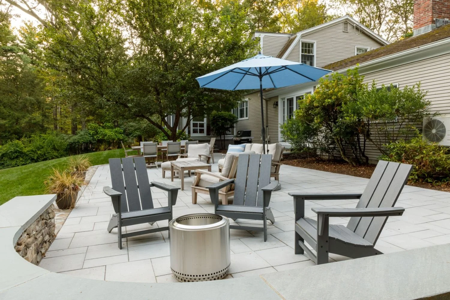 Lounge seating arrangement on backyard patio with neutral furnishings in Lexington, MA