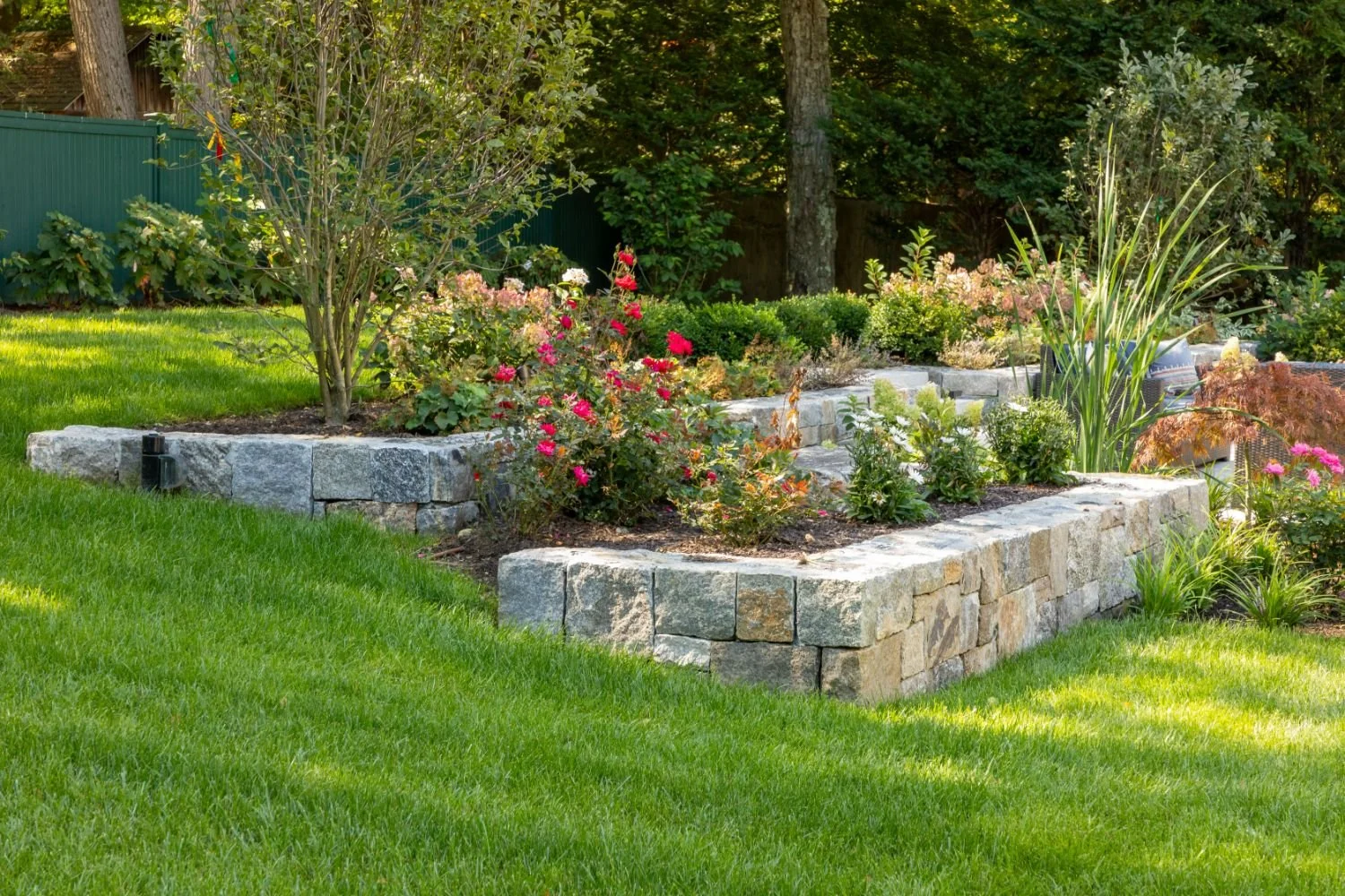 Stone steps and retaining wall at front entry designed by landscapers near me in Arlington, MA