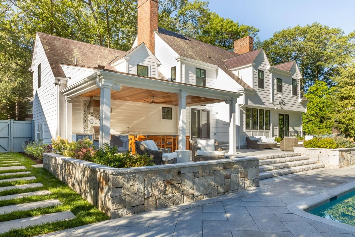 Covered patio overlooking the backyard and pool area in Newton, MA