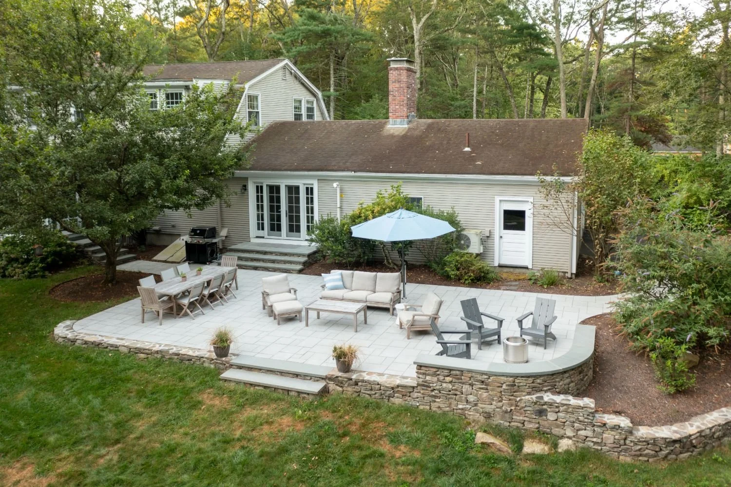 Backyard patio with umbrella seating and dining area in Lexington, MA