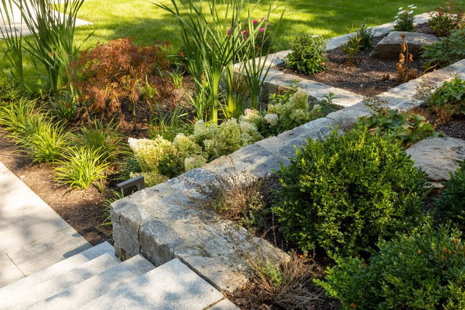 Bluestone patio edge and retaining wall detail by premier pavers & hardscape co in Arlington, MA