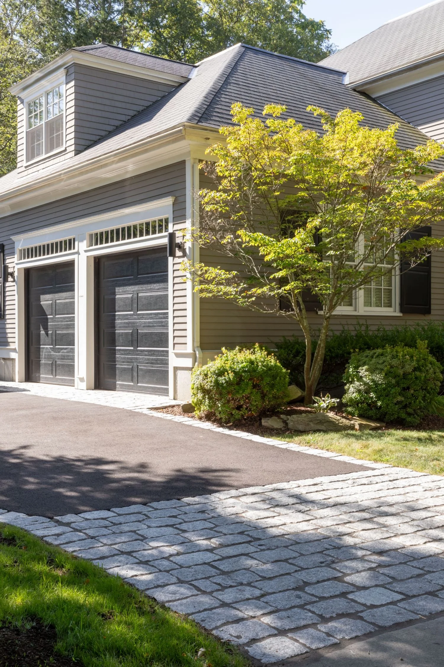 Driveway pavers and garage entry designed by landscapers near me in Arlington, MA