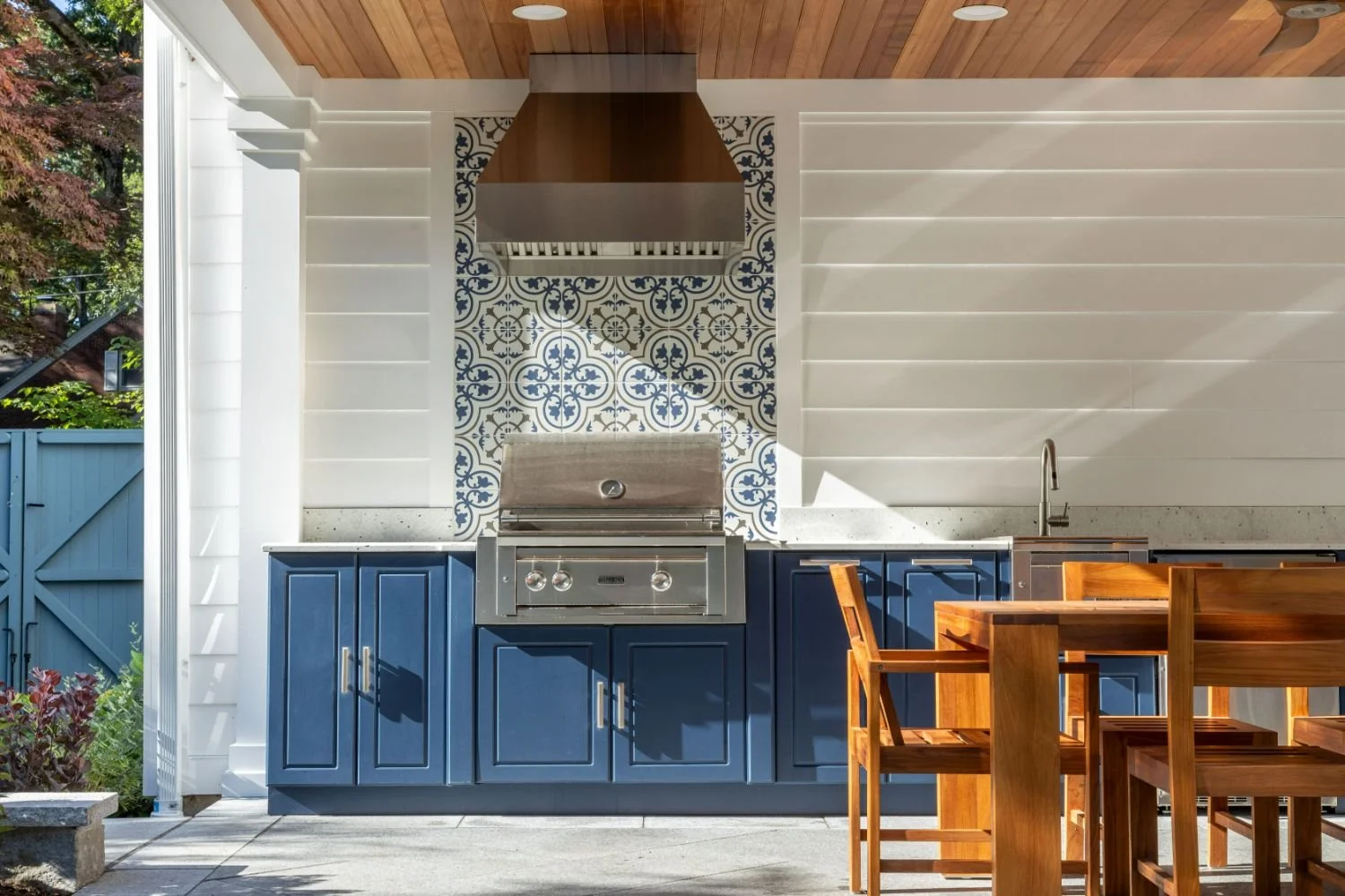 Custom outdoor kitchen with stone backsplash and built-in grill in Newton, MA