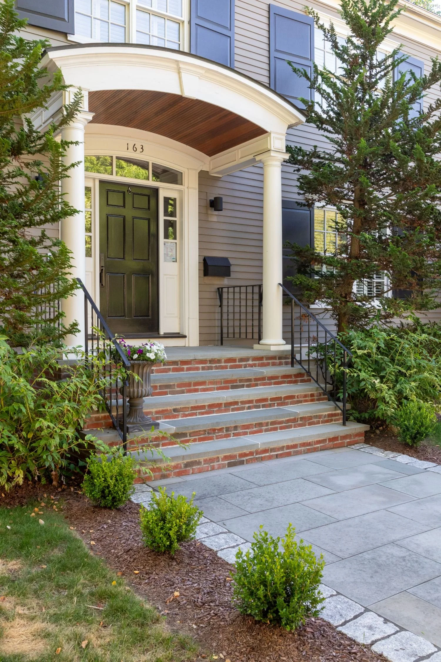 Reimagined front entry with stone steps and patio pavers in Arlington, MA