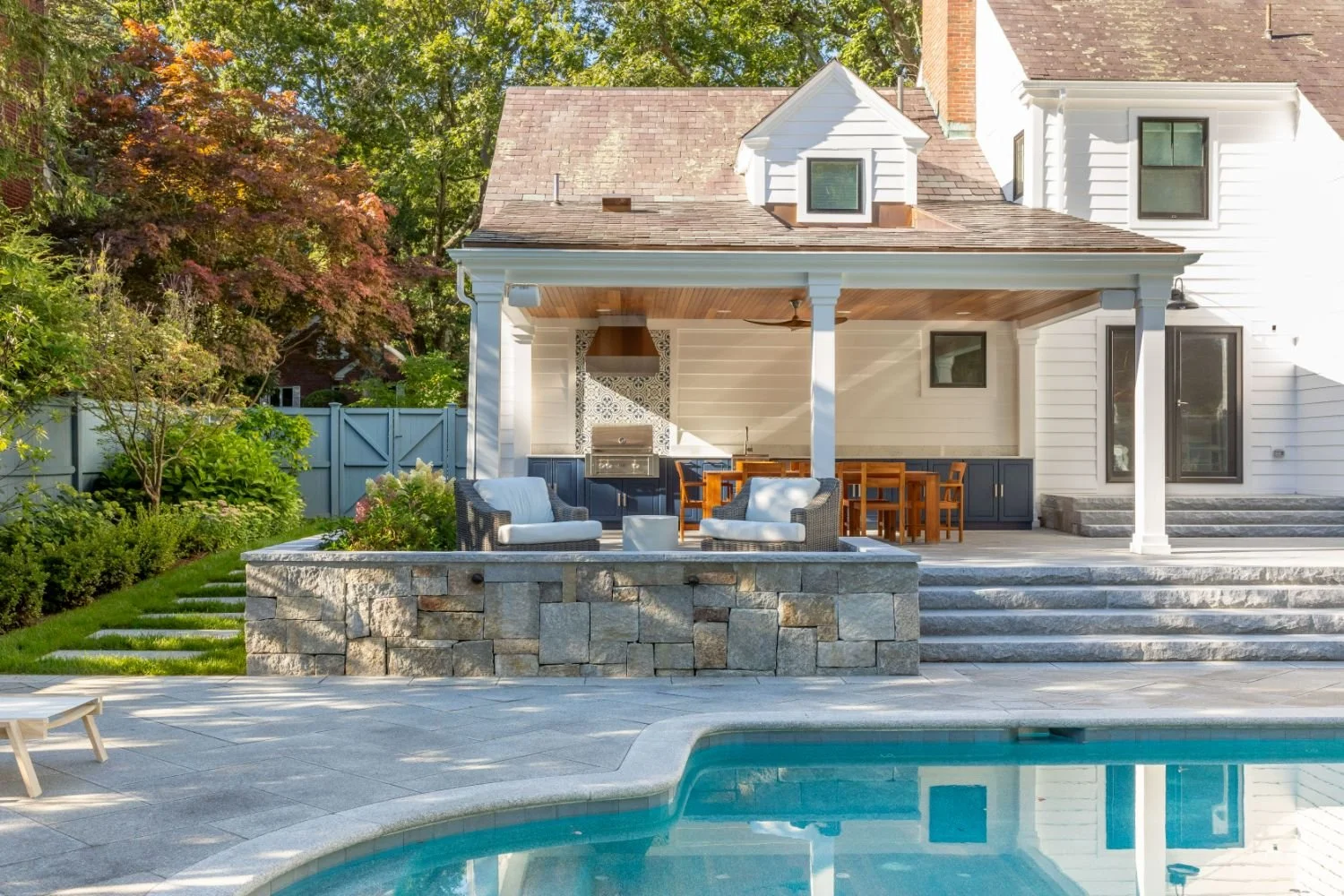 Pool and patio layout connecting covered outdoor living spaces in Newton, MA