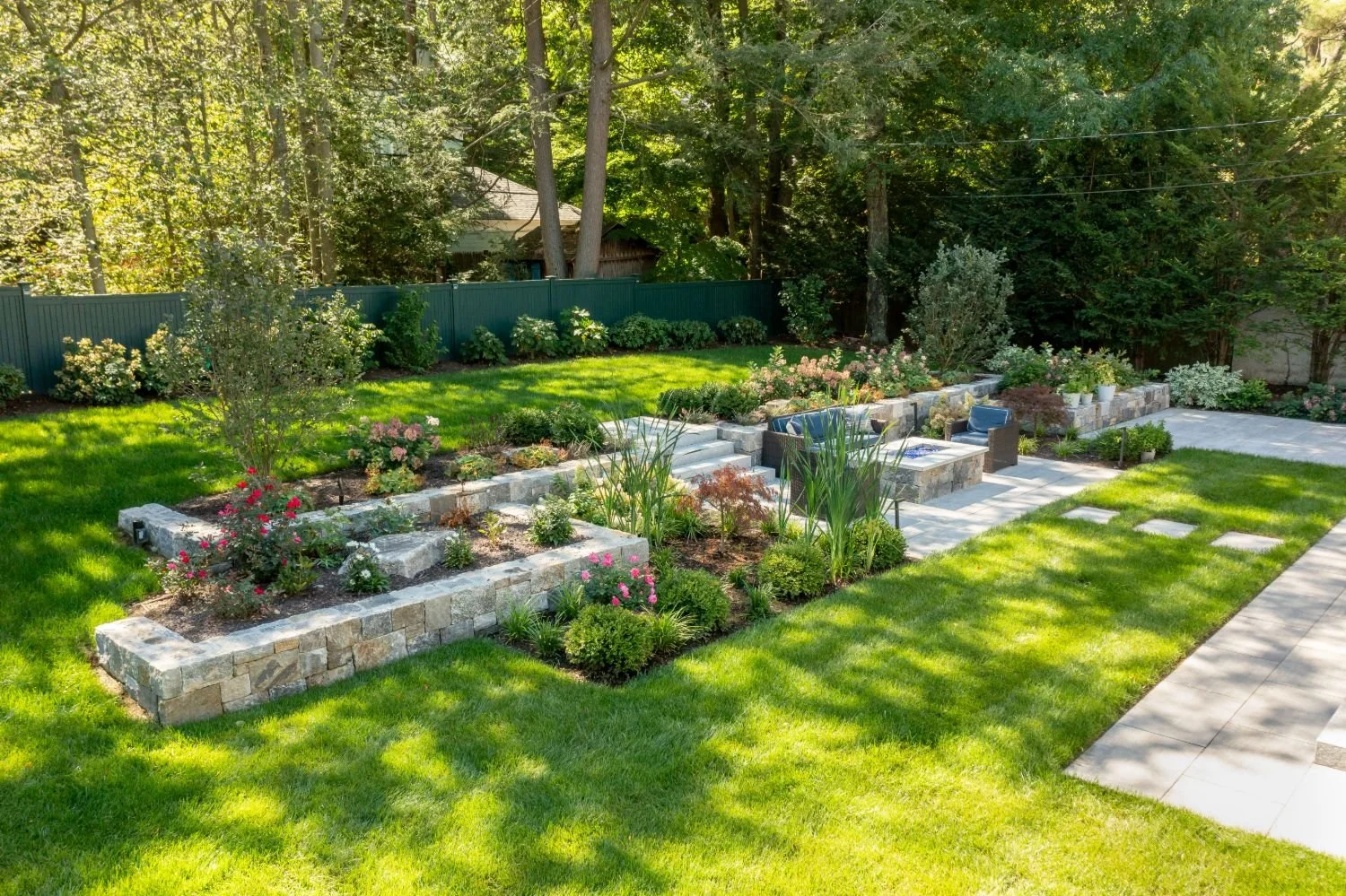 Landscape design with stone retaining walls and garden beds in Arlington, MA