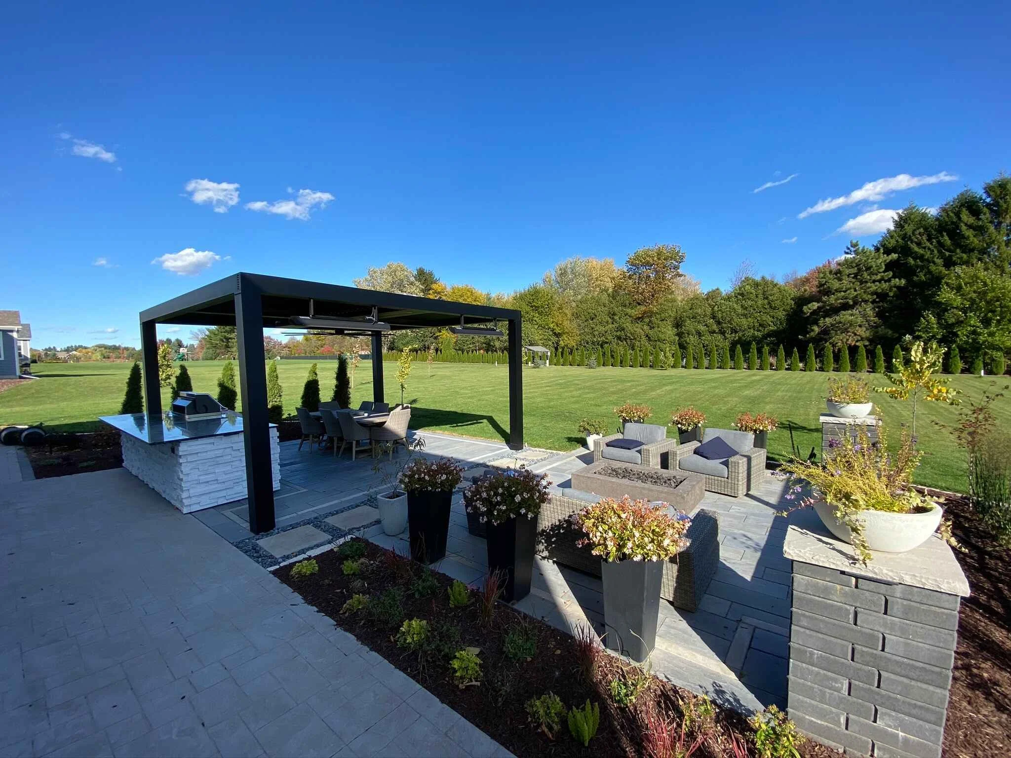 Modern outdoor kitchen and dining area under a pergola in Verona, WI