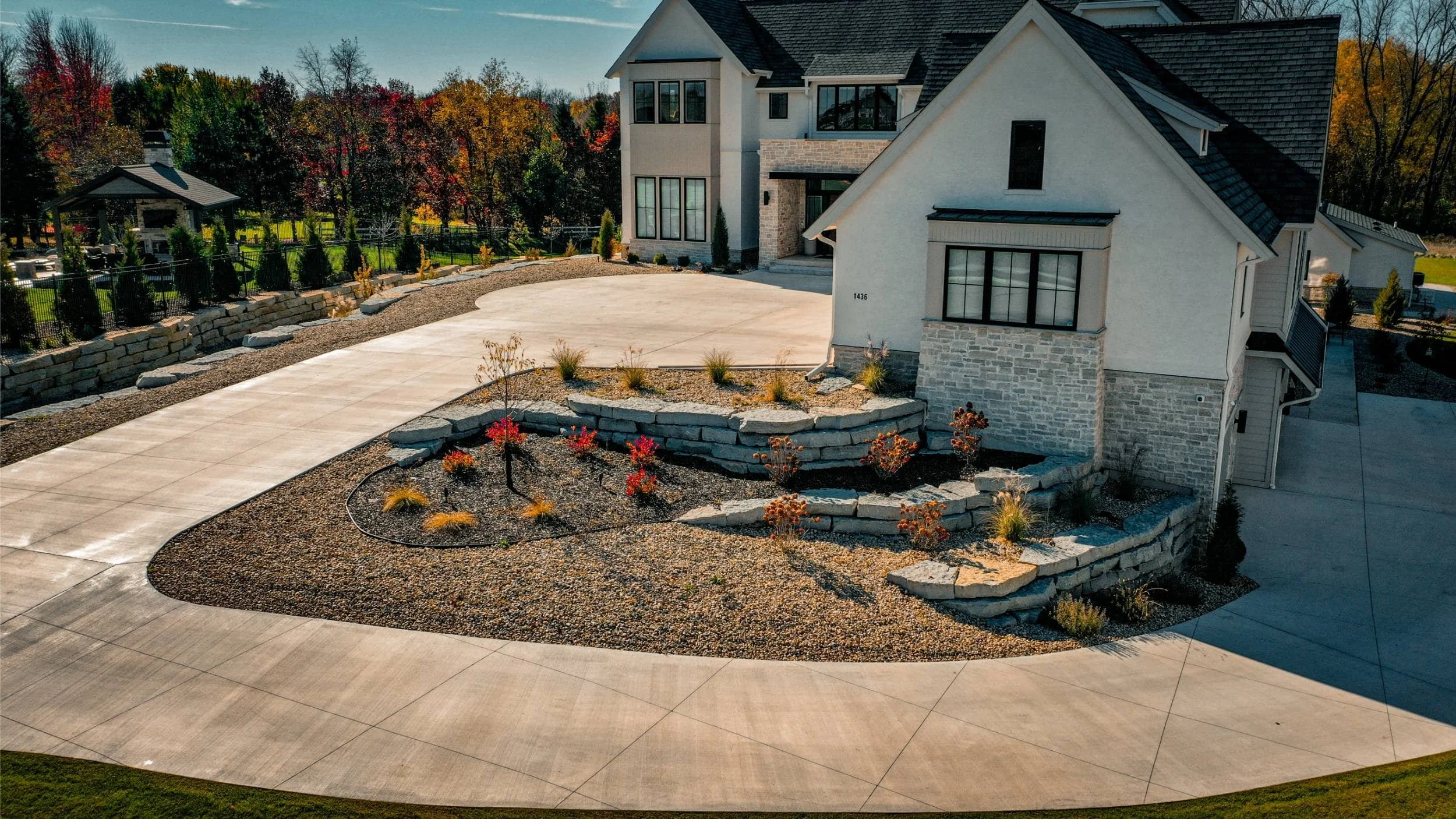 Tiered natural stone retaining walls with modern home landscaping on a slope in Madison, WI