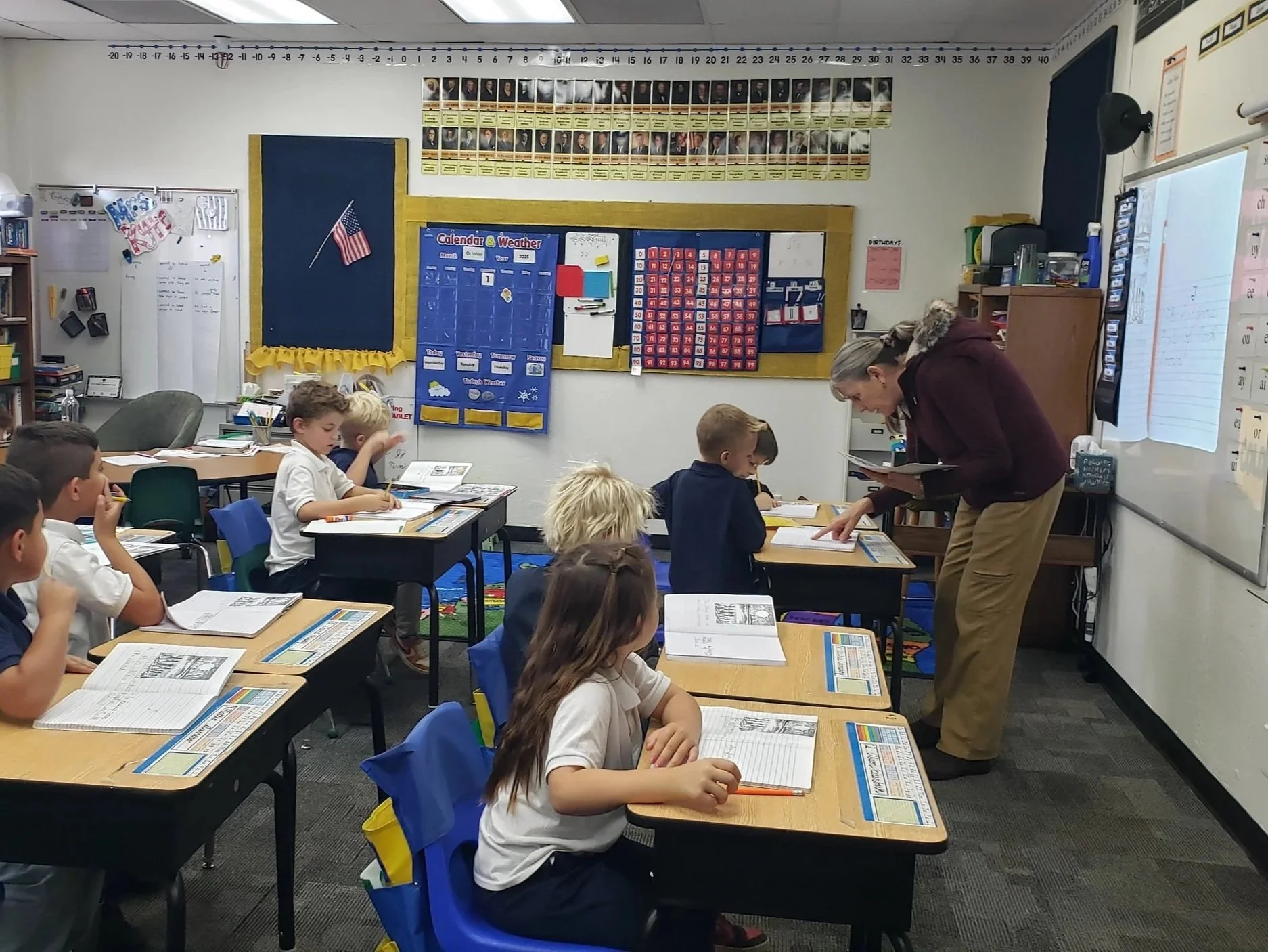A group of children sitting on a colorful carpet, each holding a children's Bible, engaging in a classroom activity.