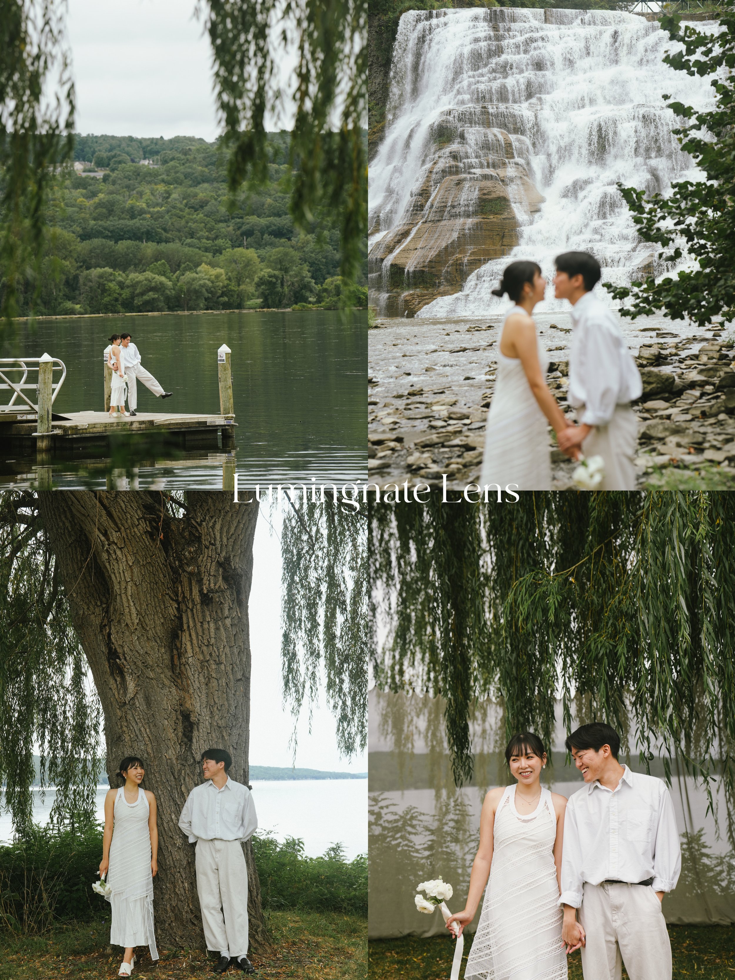 A couple dressed in white, holding hands and smiling, standing under a large tree by a lake with a waterfall in the background.