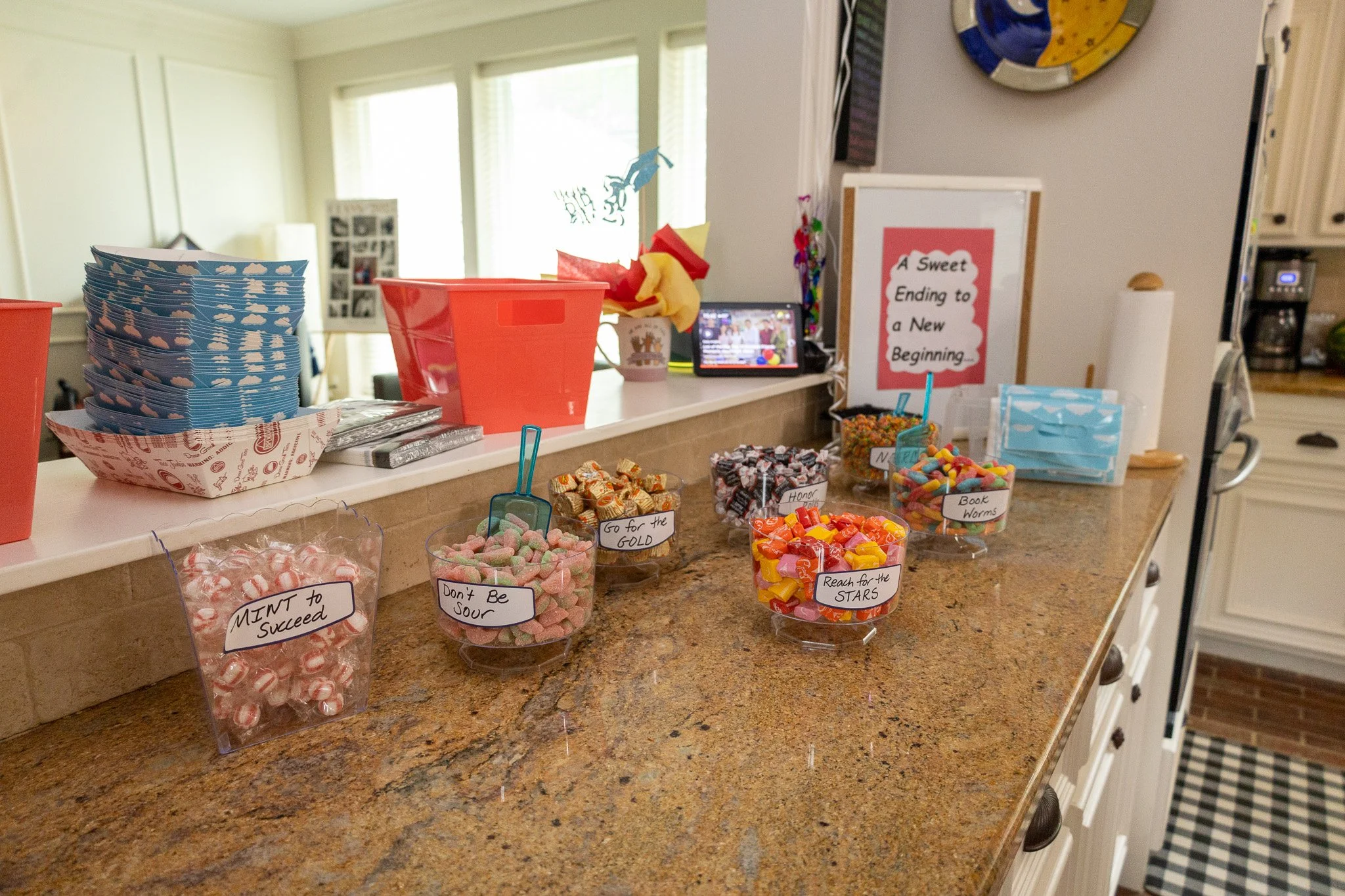 Candy display on kitchen counter with jars of candy labeled 'MINT to Succeed,' 'Don't Be Sour,' 'Go for the GOLD,' 'Reach for the STARS,' 'Honey,' and 'Book Worms.'