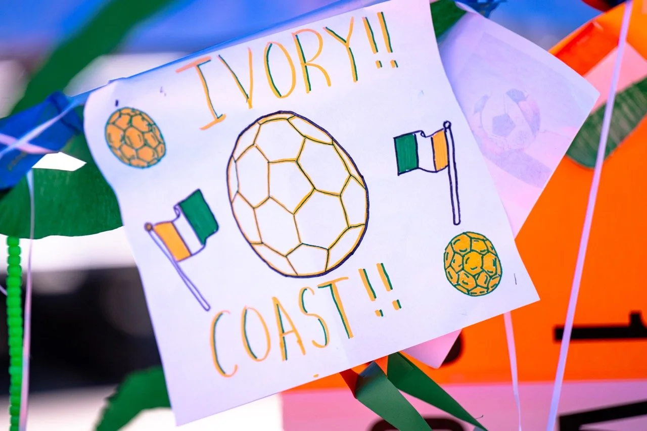 A colorful handcrafted sign with a soccer ball, two Irish flags, and the text 'Ireland!! Coast!!' surrounded by decorative elements, displayed on a white sheet of paper.