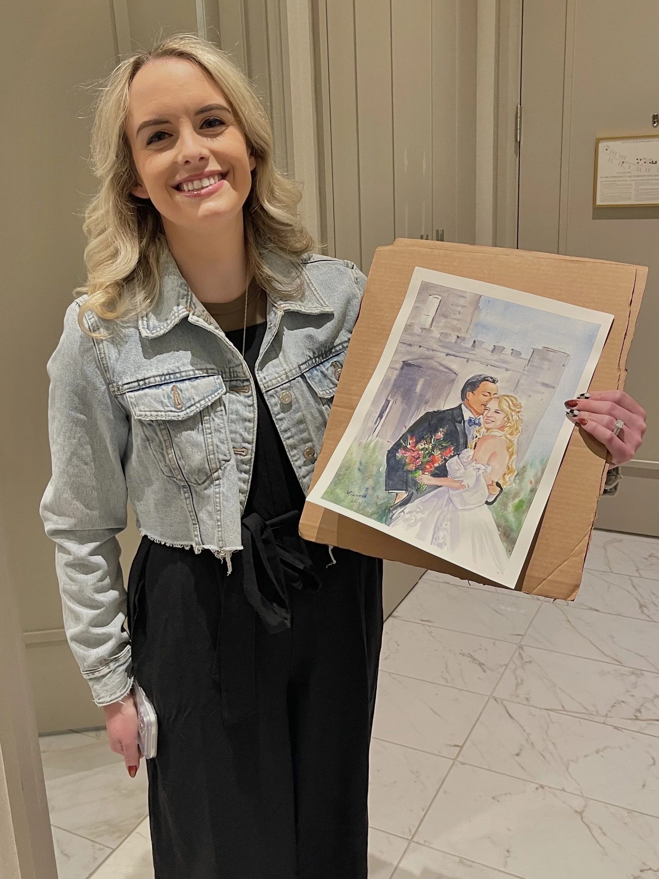 Client holding her custom watercolor wedding portrait