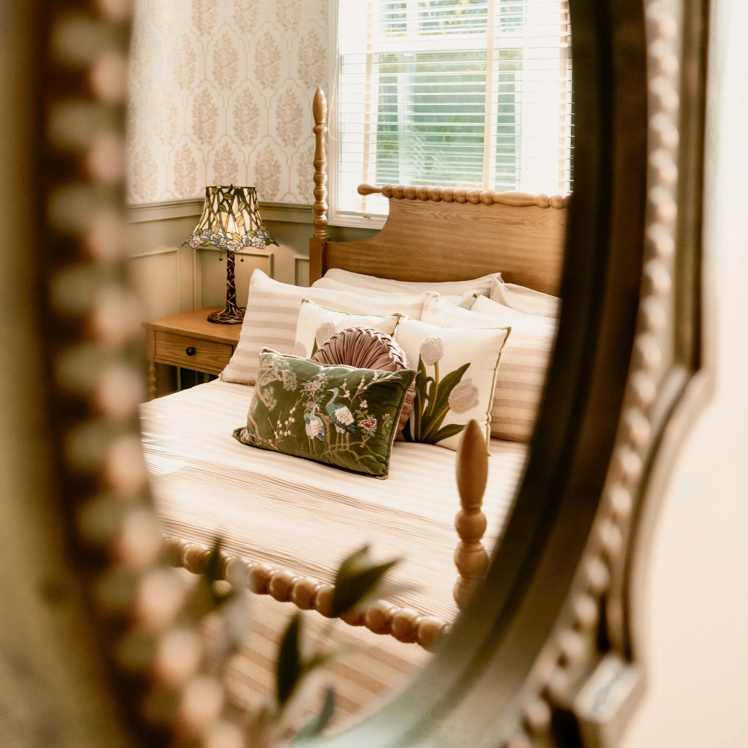 Inside a bedroom viewed through the slats of a decorative wooden headboard.