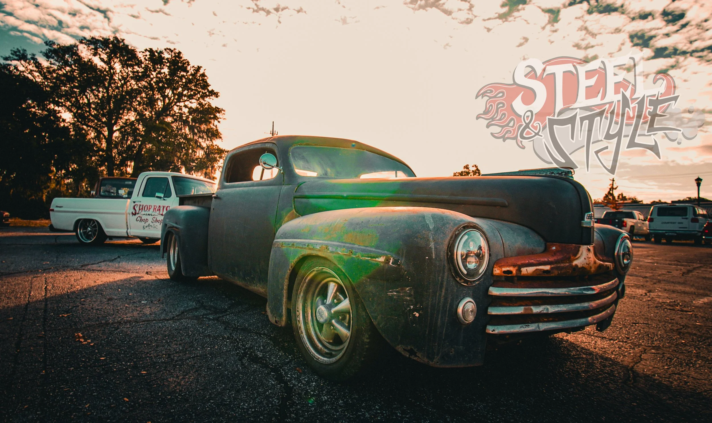 Old, rusty pickup truck parked on a cracked asphalt lot at sunset with another vintage truck in background and a logo of 'Stel & Myrtle' in the top right corner.
