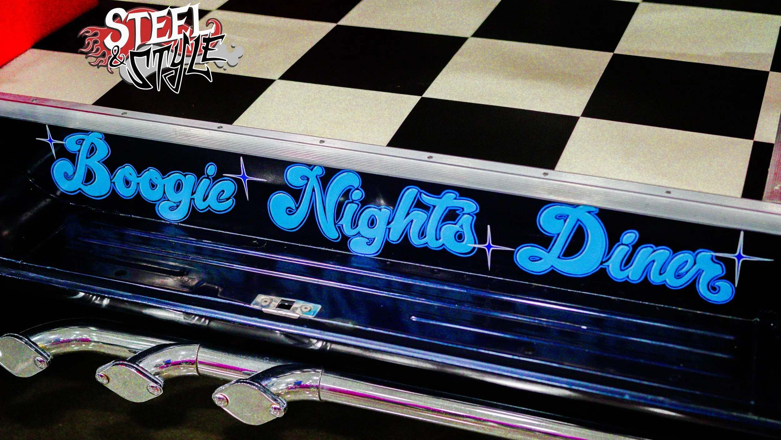 A neon sign that reads 'Boogie Nights Diner' in bright blue lights, with a black and white checkered floor pattern above.