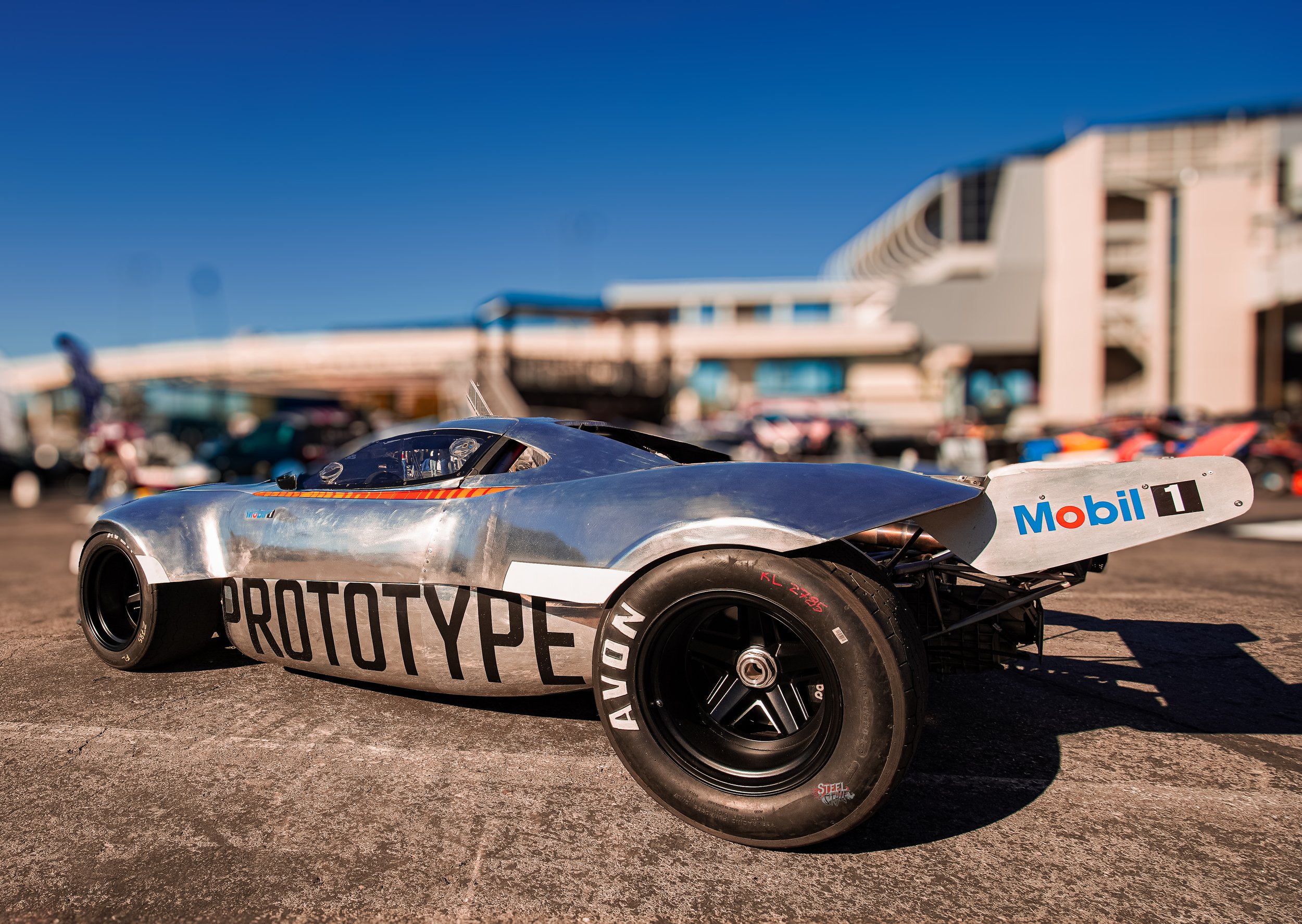 A sleek race car with a metallic body and black tires, marked with 