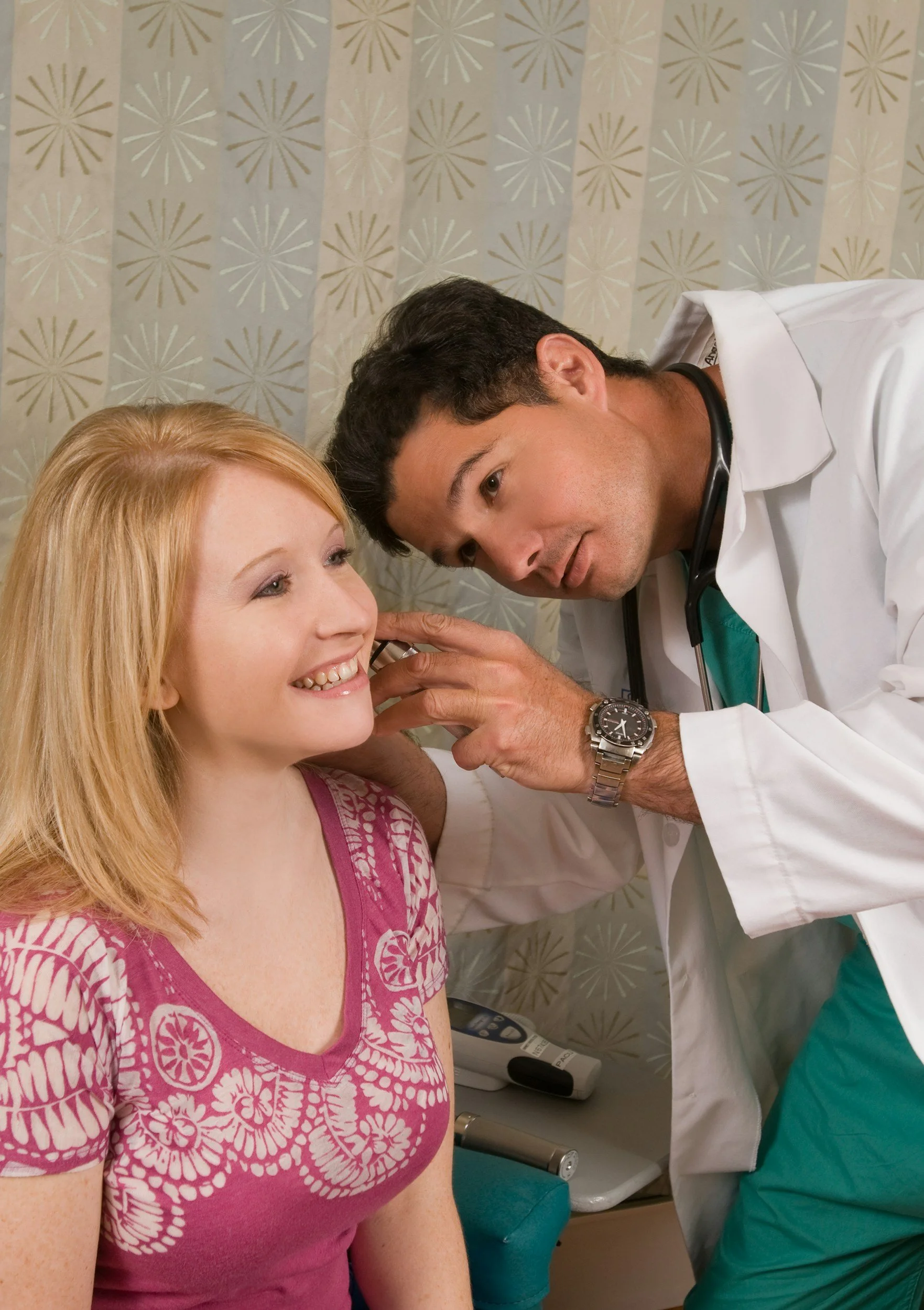 A healthcare worker administering a vaccination to a man sitting on a stool.