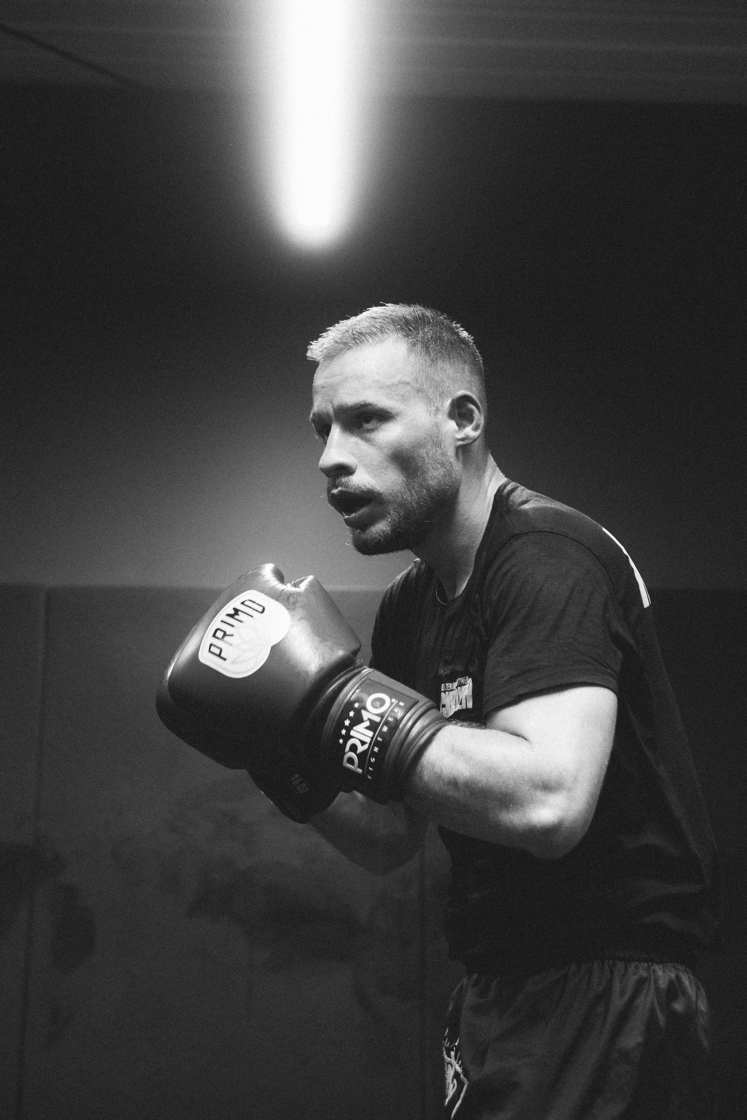 Schwarzer und weißer Boxer in Kampfstellung mit Boxhandschuhen, getragen von Marken "PRIMO".