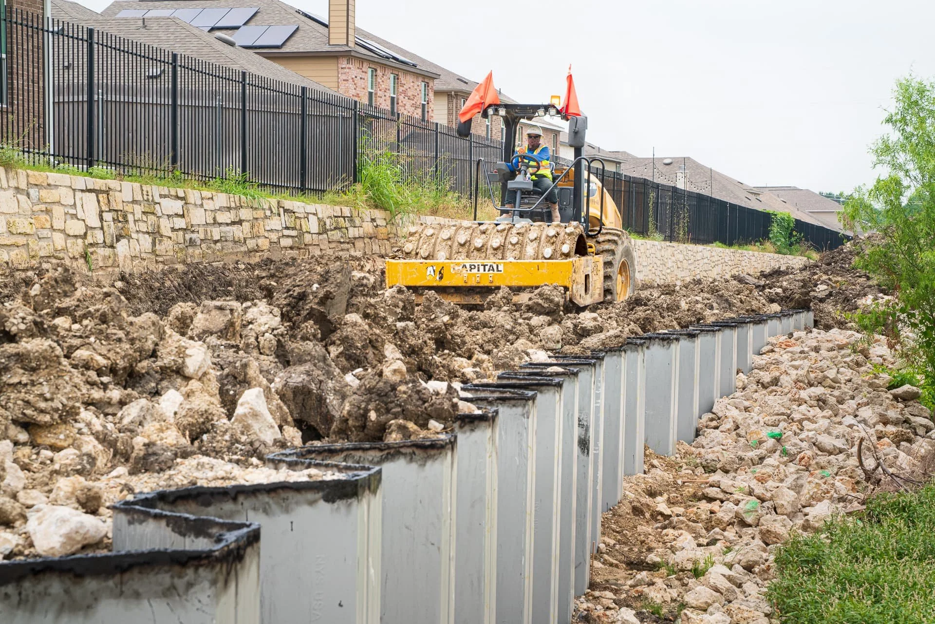 Compactor working on excavation for road and bridge construction in Austin, Texas, photographed for Section 01380 documentation.