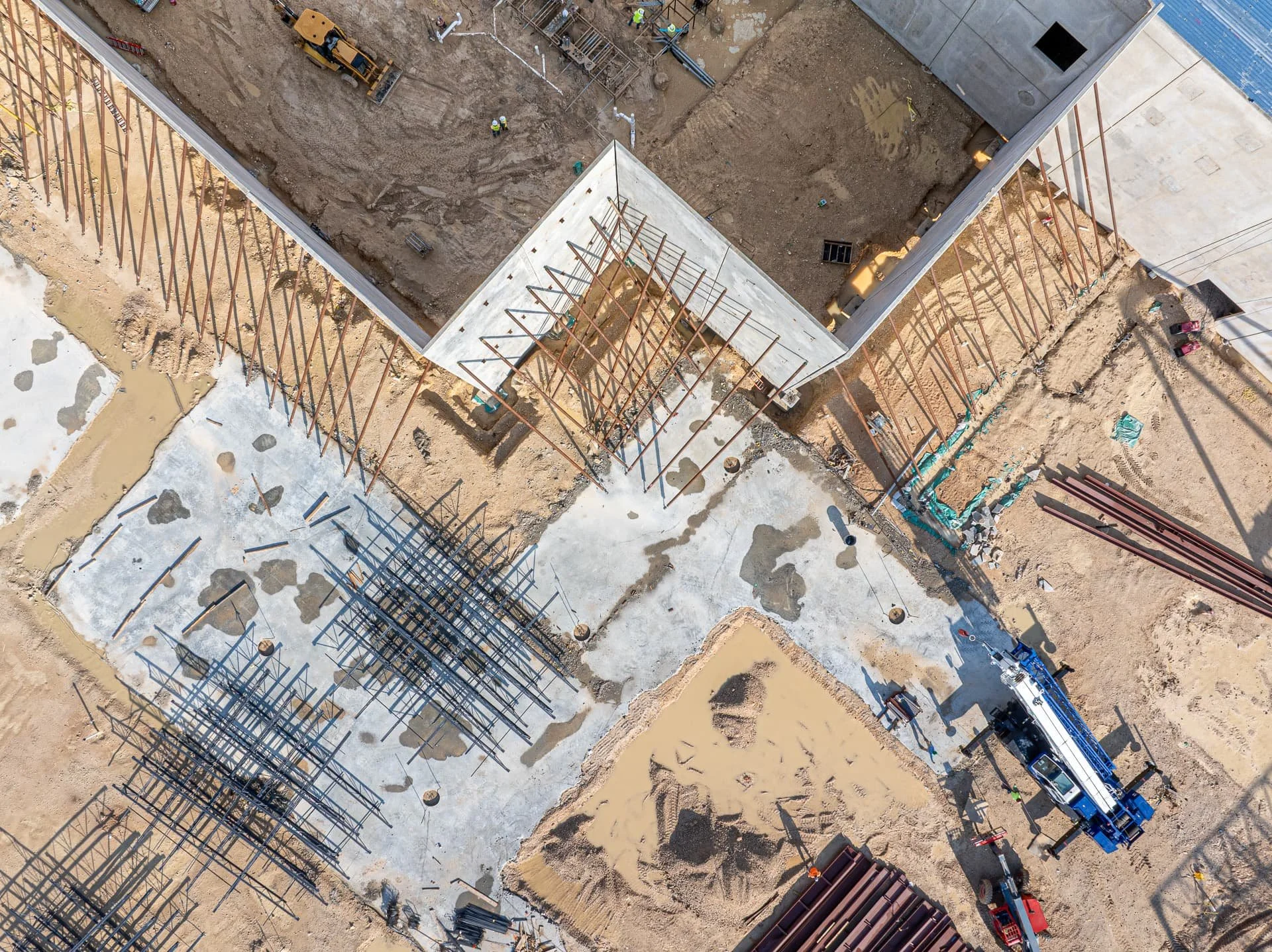 Overhead drone view of tilt-up concrete wall panels braced during warehouse construction in Austin, Texas.