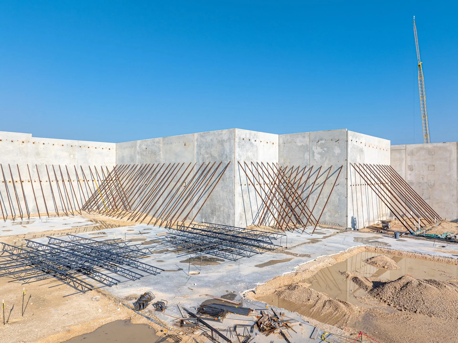 Overhead drone view of tilt-up concrete wall panels braced during warehouse construction in Austin, Texas
