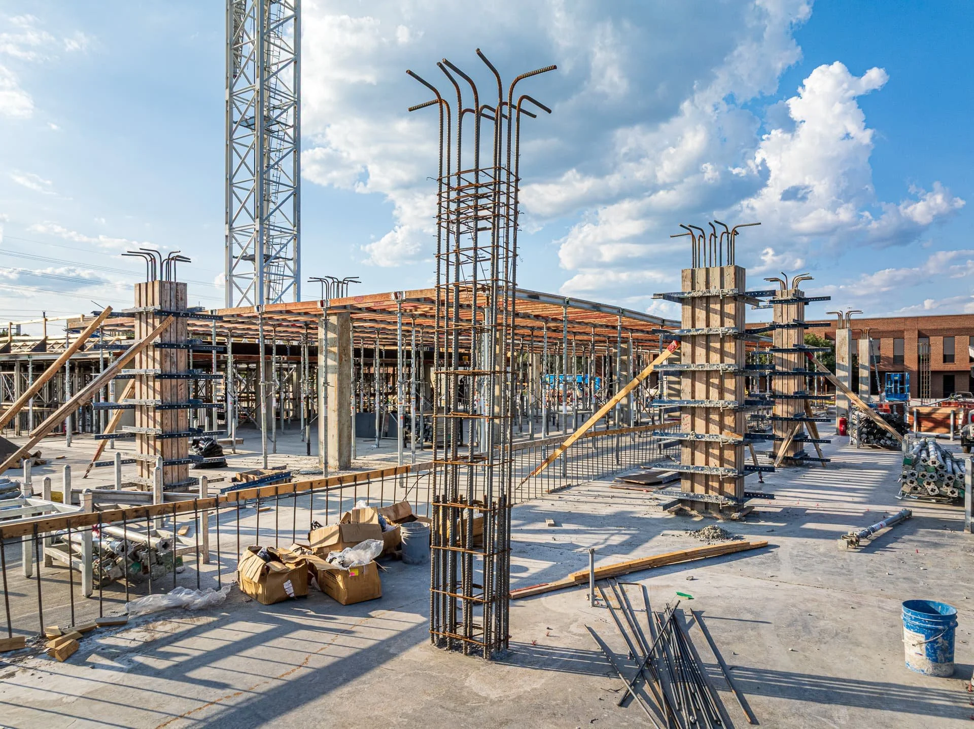 Axially loaded reinforced concrete column with rebar cage at multi-story apartment building construction site in Austin.