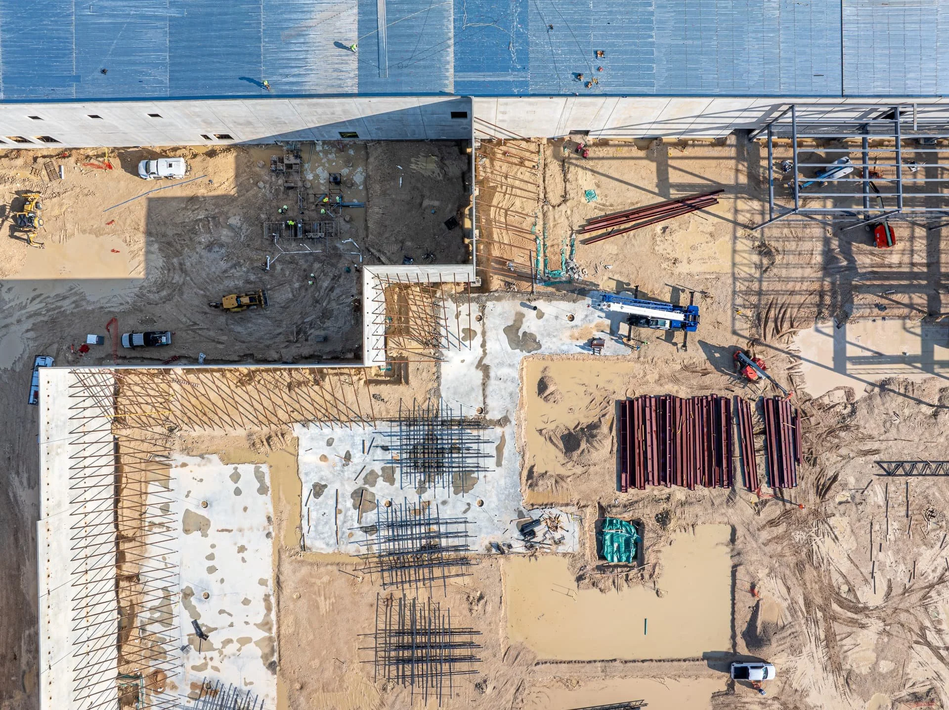 aerial construction photos of overhead site in Austin with steel, concrete, and materials staged for installation.