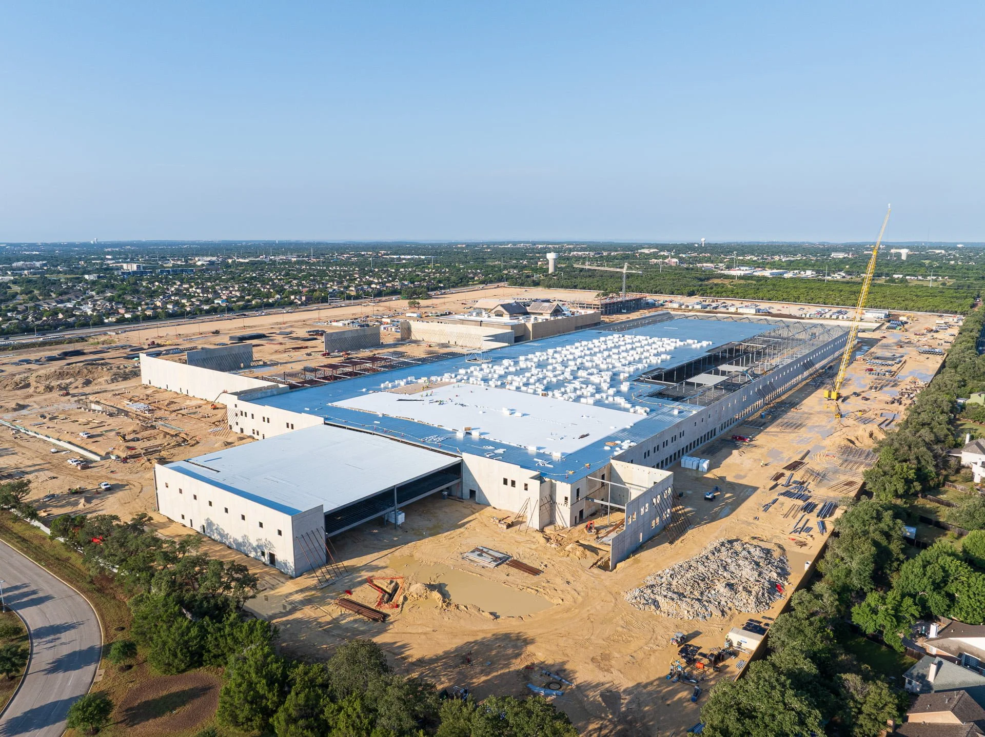 Drone aerial photo of large-scale tilt-up concrete warehouse construction progress at Nebraska Furniture Market site in Texas.