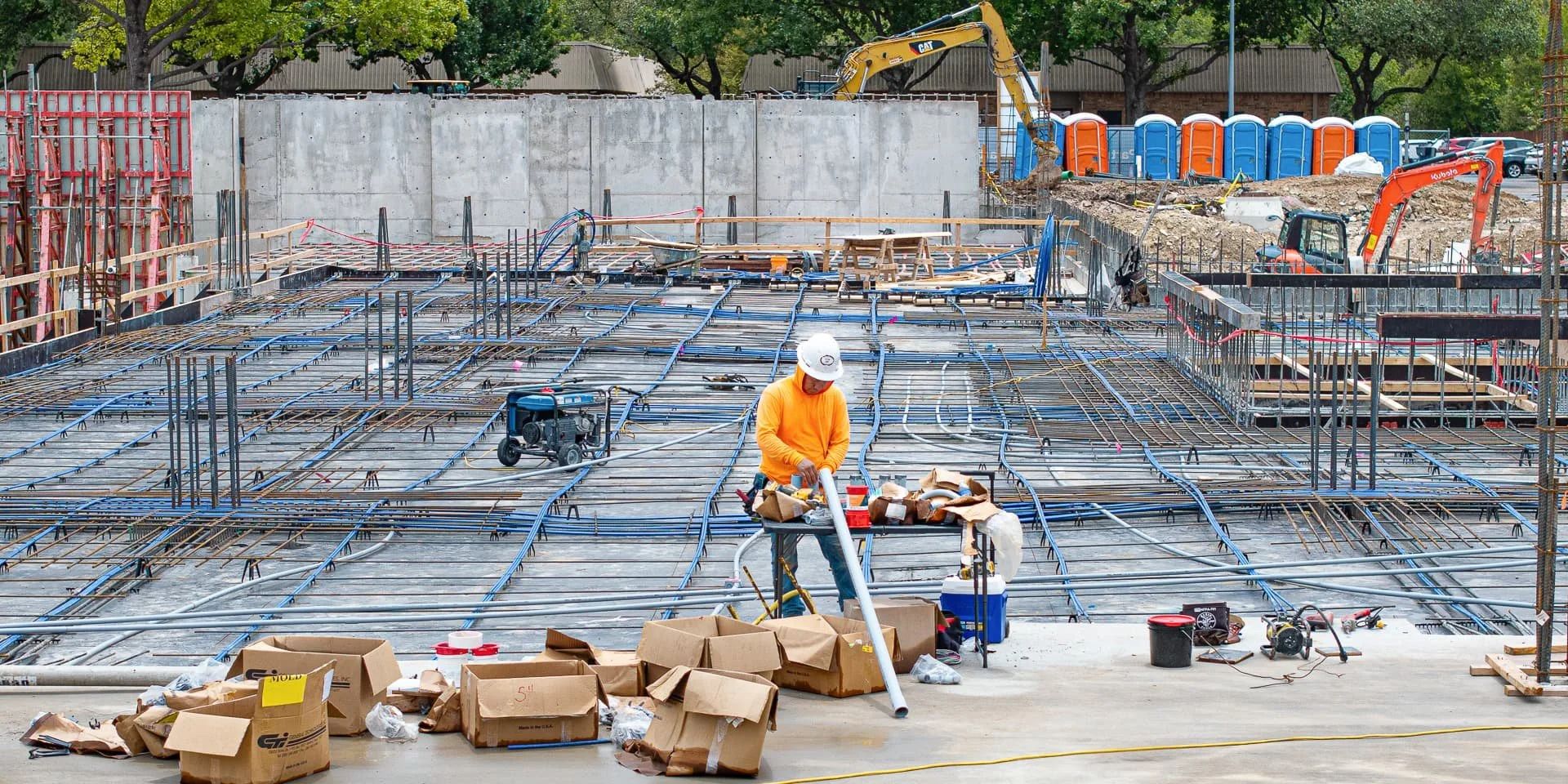 drone image of Post-tension cables and foundation plumbing installation at commercial building site in Austin, Texas. Progress construction image