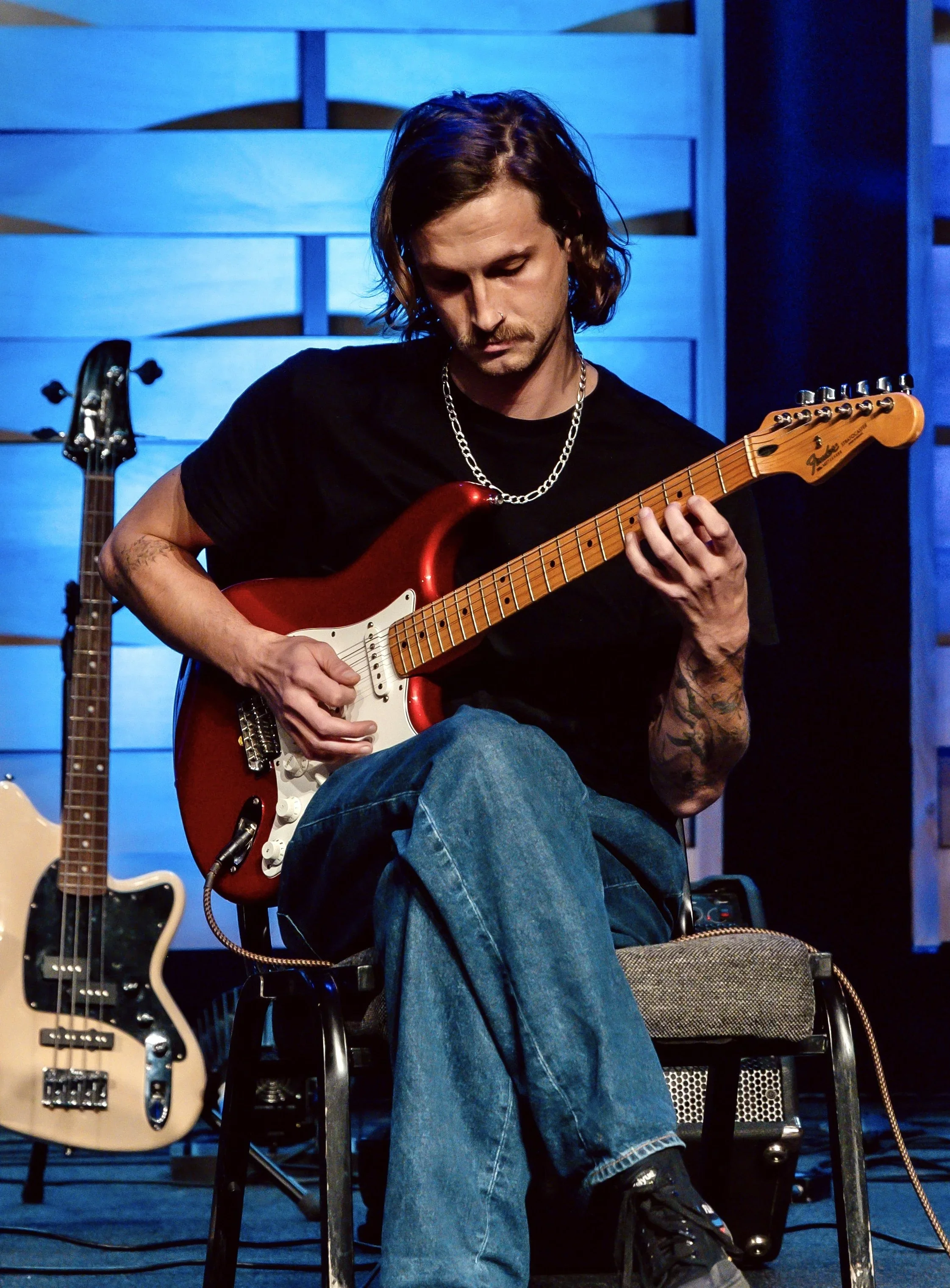 Ethan teaches guitar, bass, drums, keys, and band at the Wylie School of Music. Pictured here with an electric guitar.