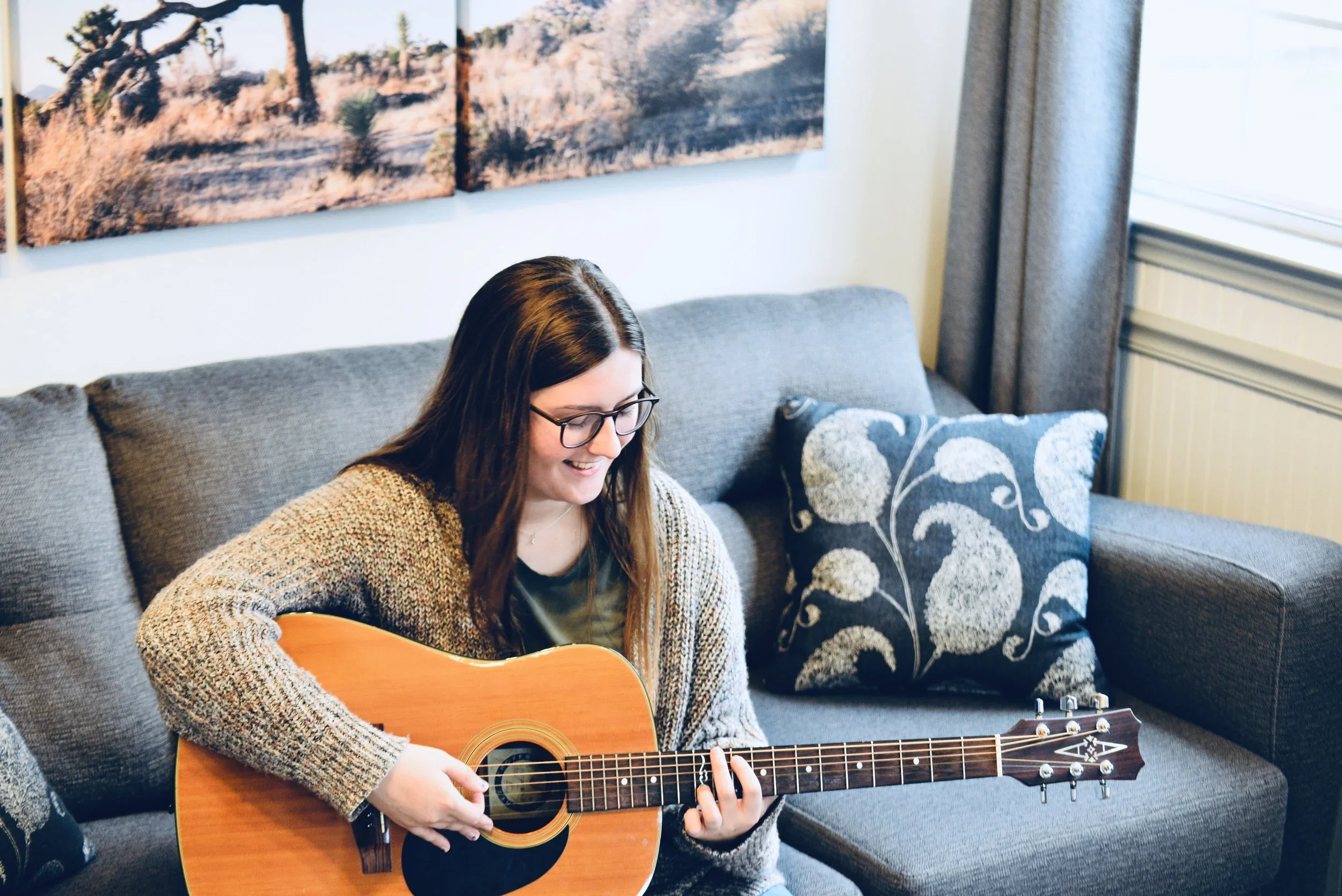 Meredith teaches voice, guitar and piano at the Wylie School of Music. Pictured here with a guitar.