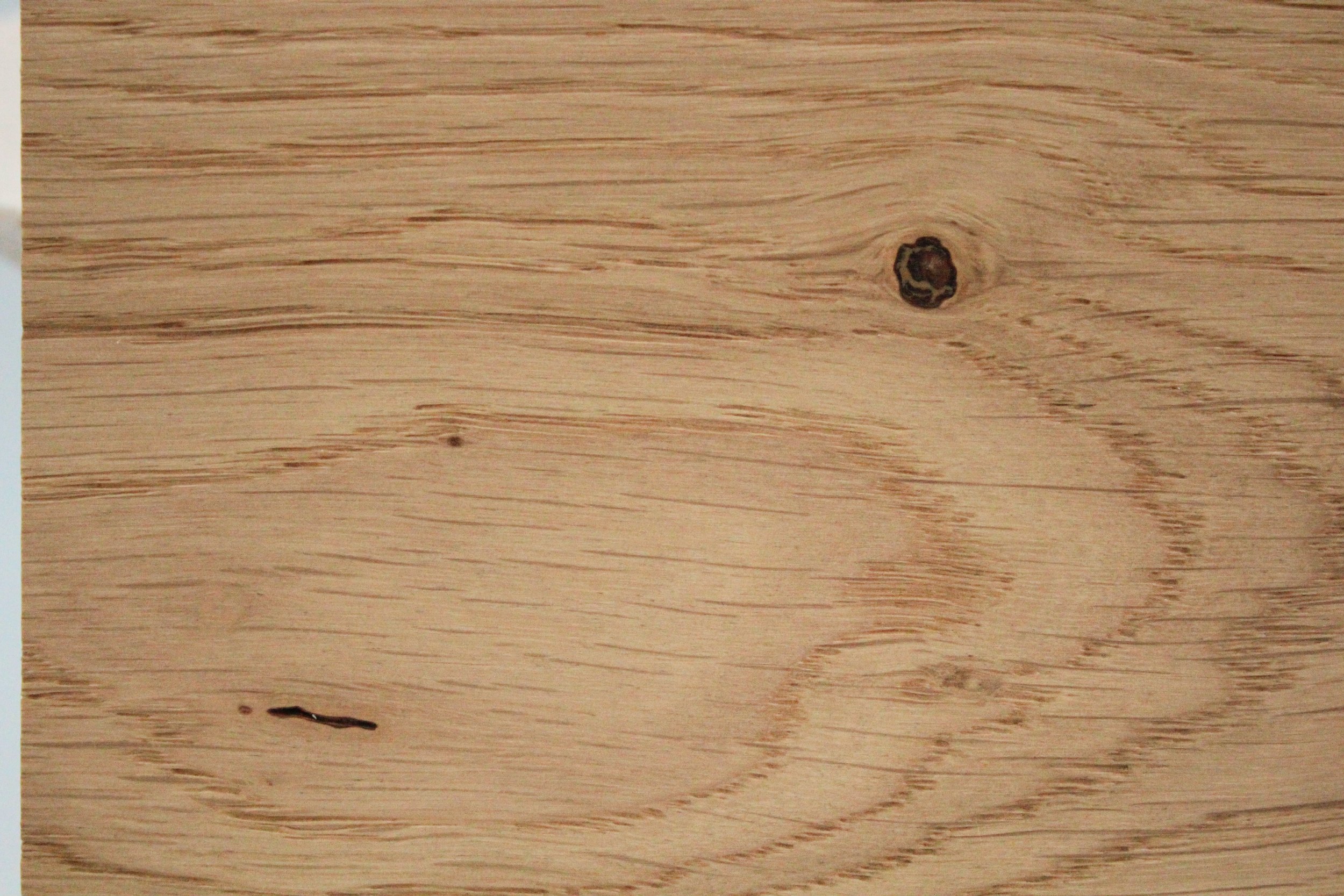 Close-up of a wooden surface with visible wood grain and knots.