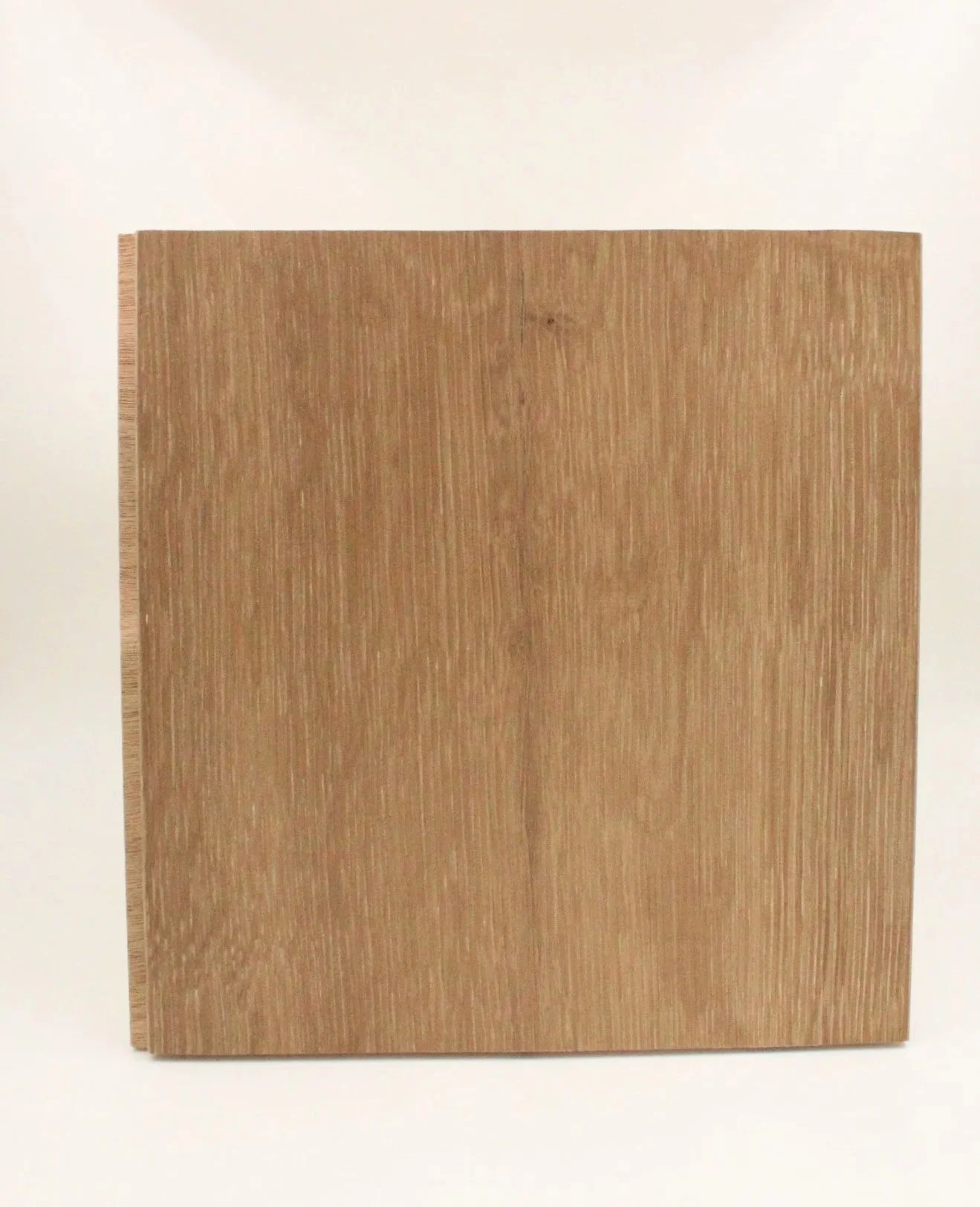 A square piece of wood with a natural grain pattern, placed upright against a plain off-white background.