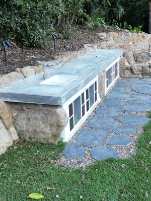 outdoor stone countertop with sink next to path