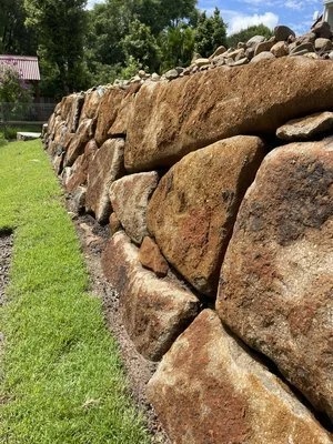 Stone retaining wall with grass lawn