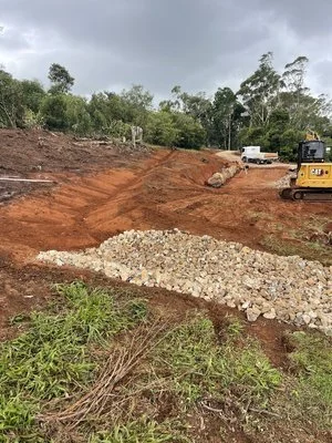Construction site with excavator, dirt, and gravel pile