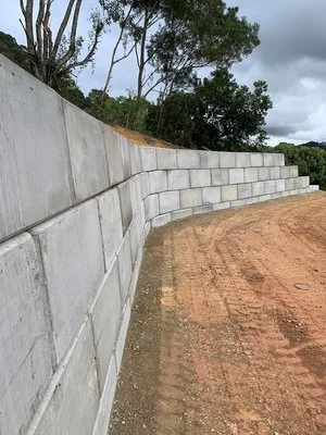 Concrete retaining wall with dirt path and trees