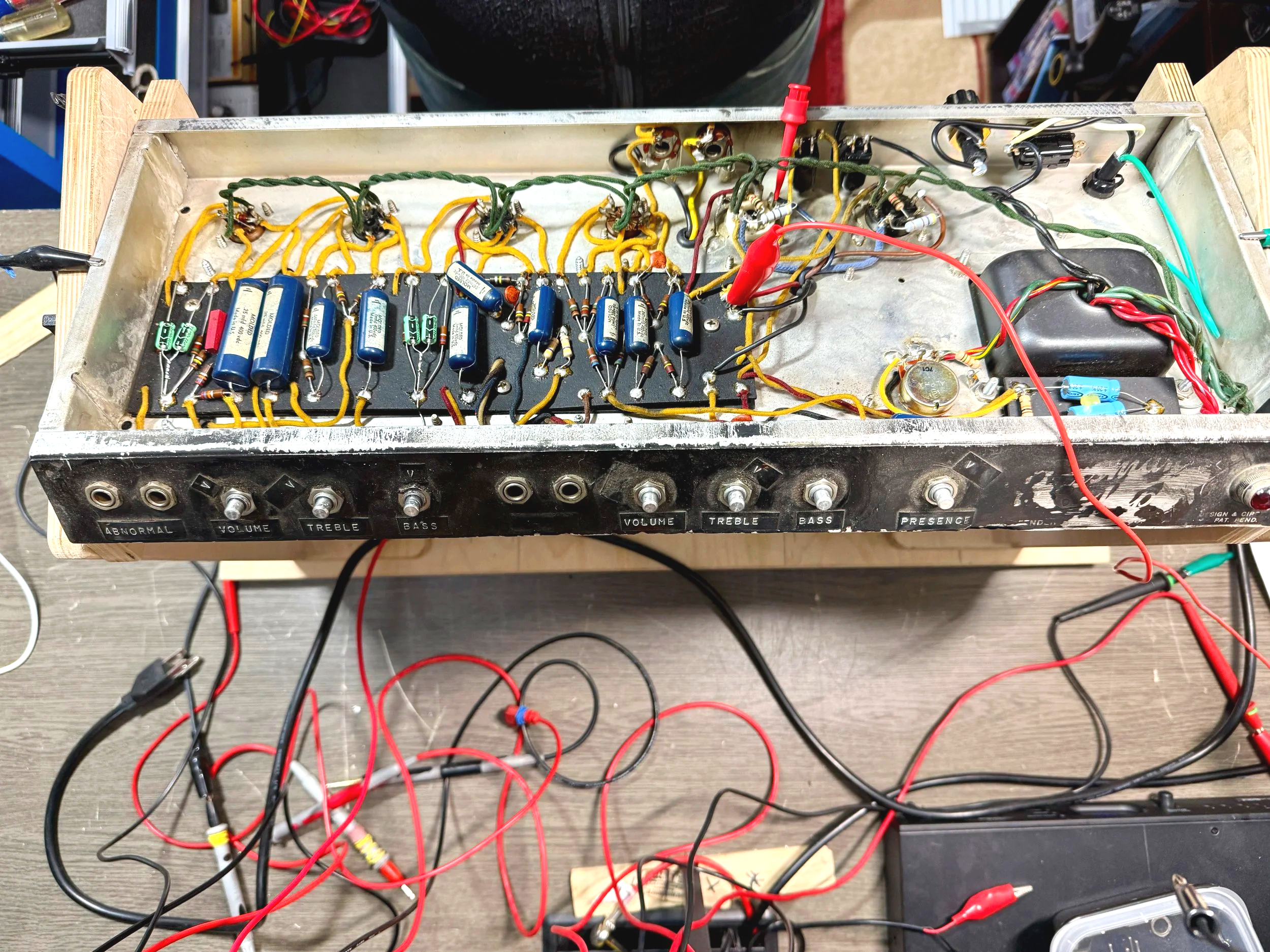 A vintage electronic device with visible vacuum tubes, resistors, capacitors, and wires inside a metal chassis.