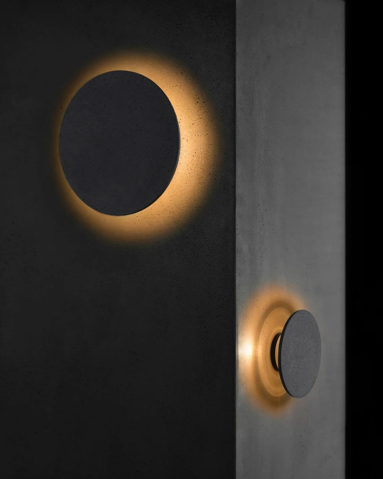 Concrete Disc Wall Light with a halo light affect installed on a concrete wall