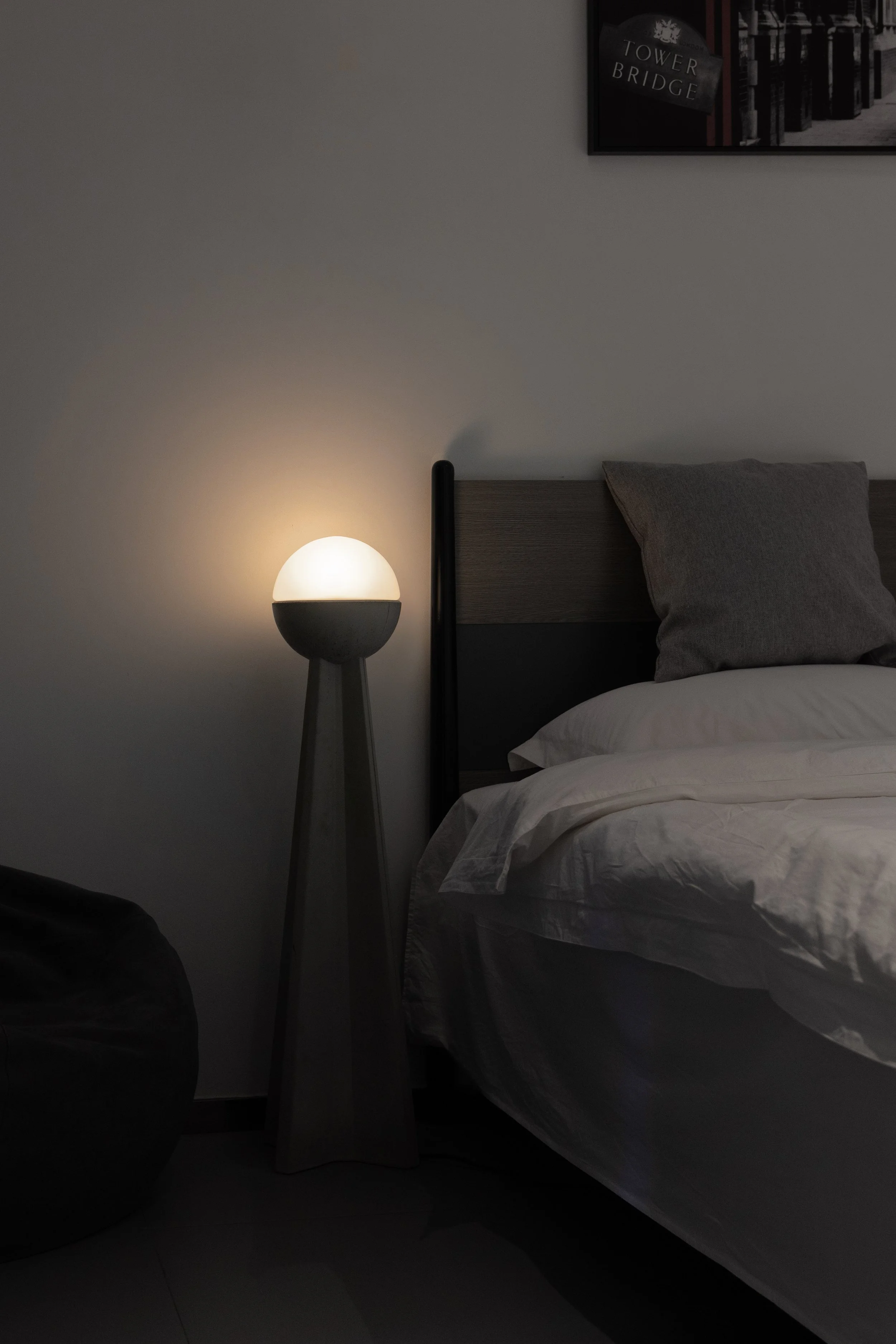 Concrete Floor Lamp next to a modern bed light on