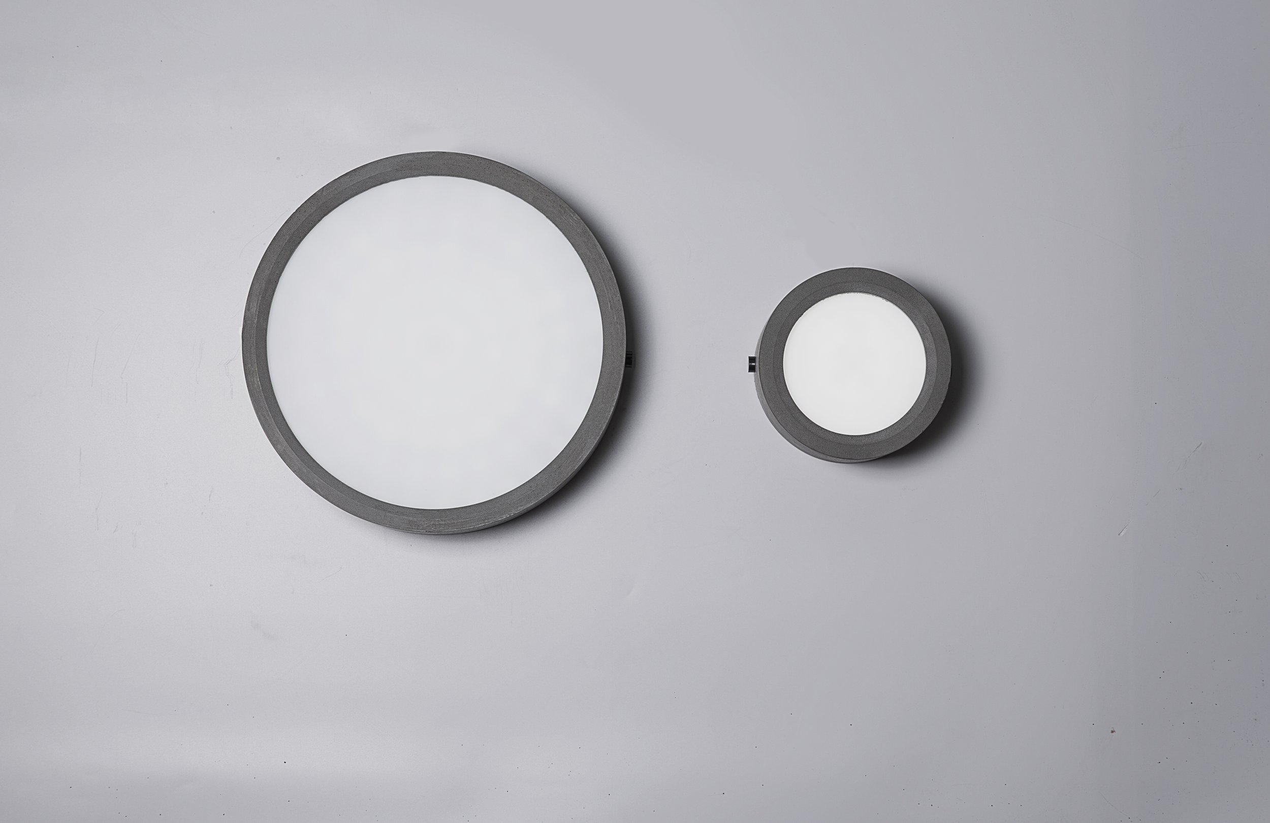 Huan Concrete Ceiling Light Small and Large installed on a grey background