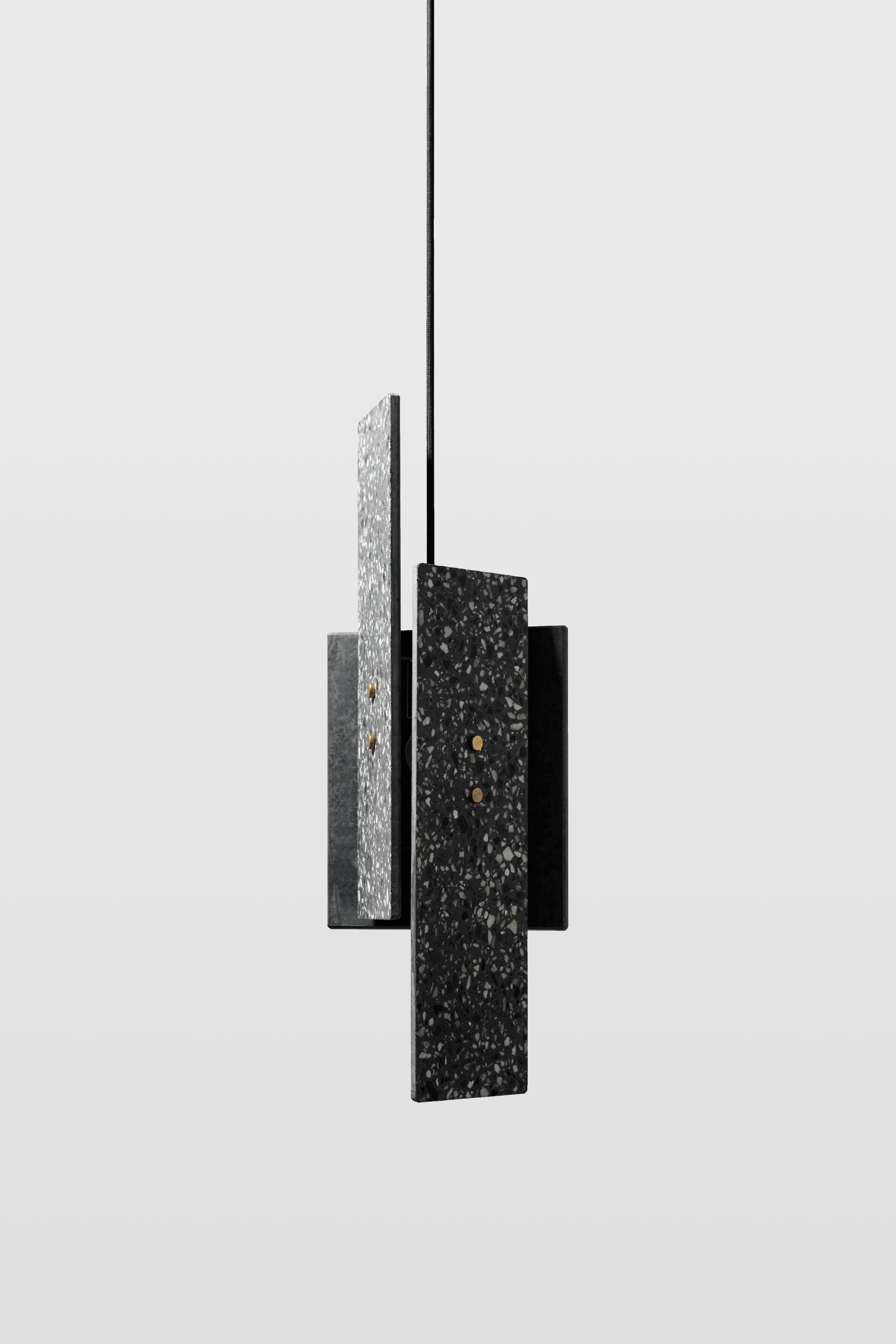 Black Terrazzo Stone Pendant Light hanging in front of a light grey background