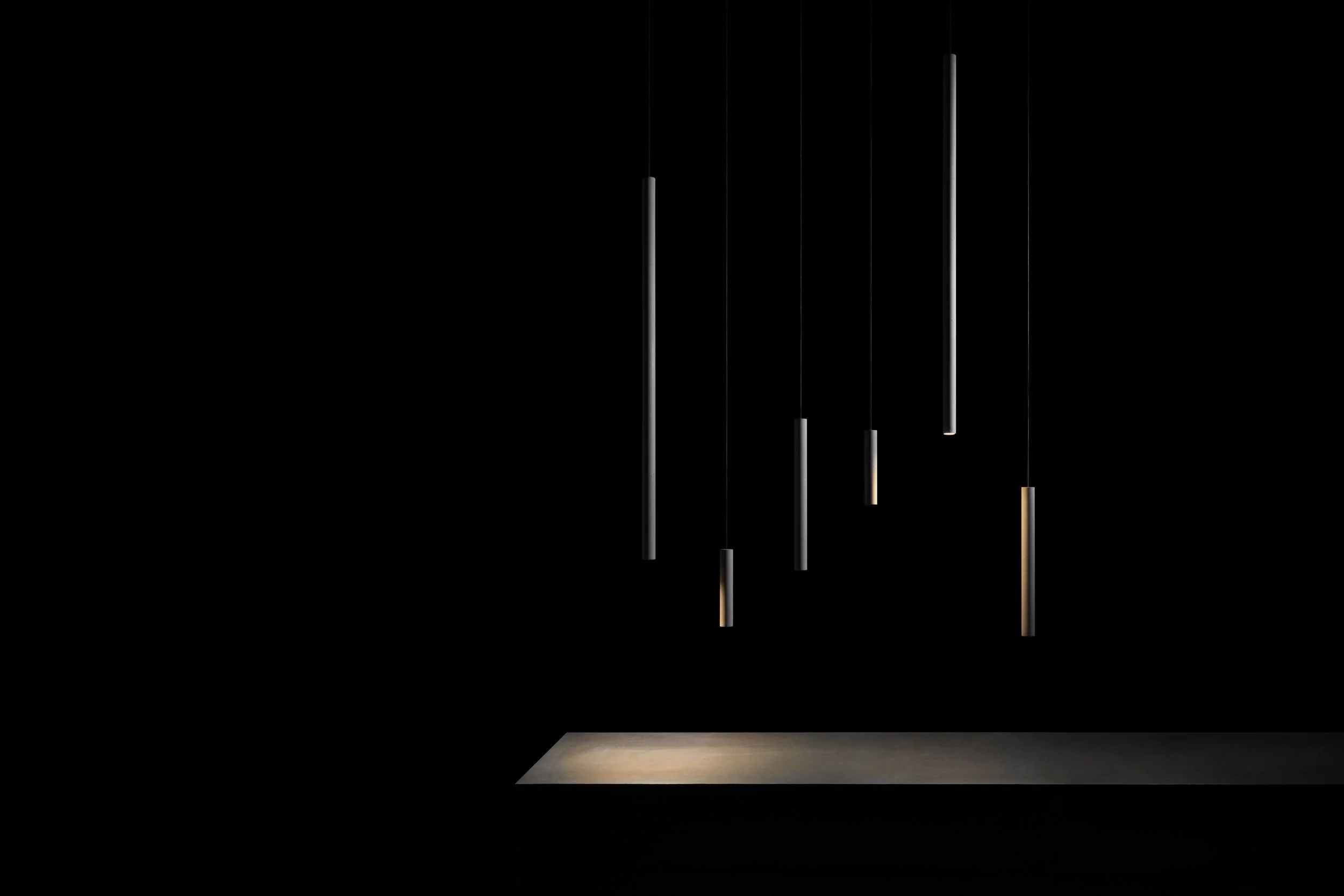 Multiple Bang2 Pendant Lights hanging in front of a Black background