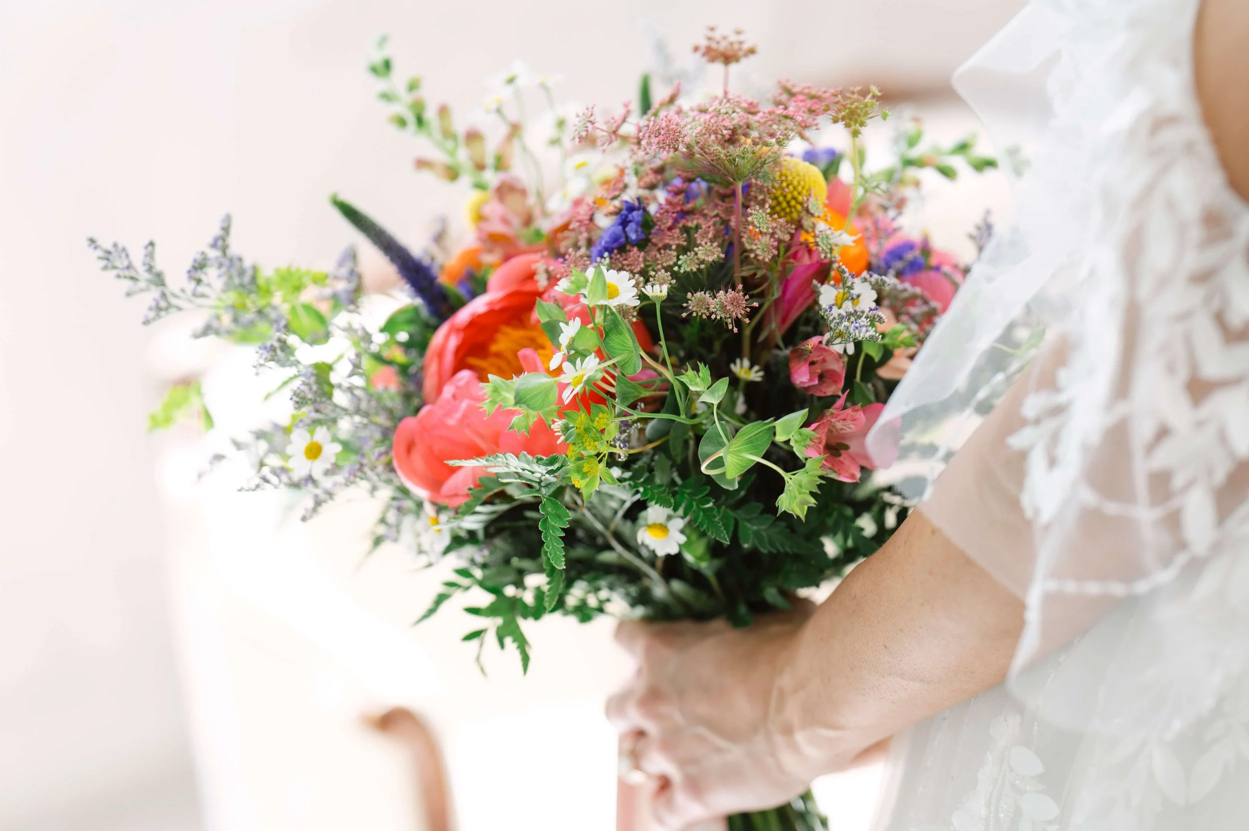 A romantic photo of a vibrant, colorful bouquet full of texture and blooms. Photographed by VanderHoff Studios.