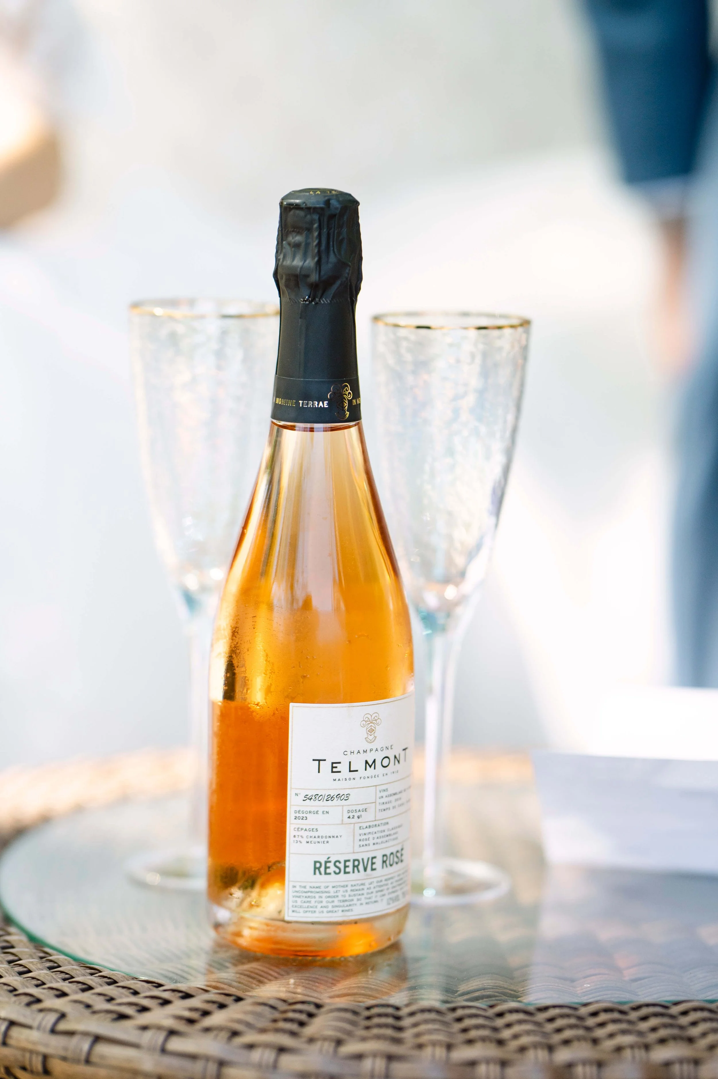 A bottle of champagne with two flutes set for a wedding toast. Photographed by VanderHoff Studios.