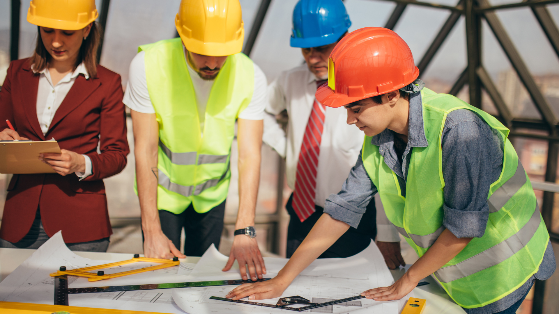Group of construction professionals reviewing blueprints on a construction site.