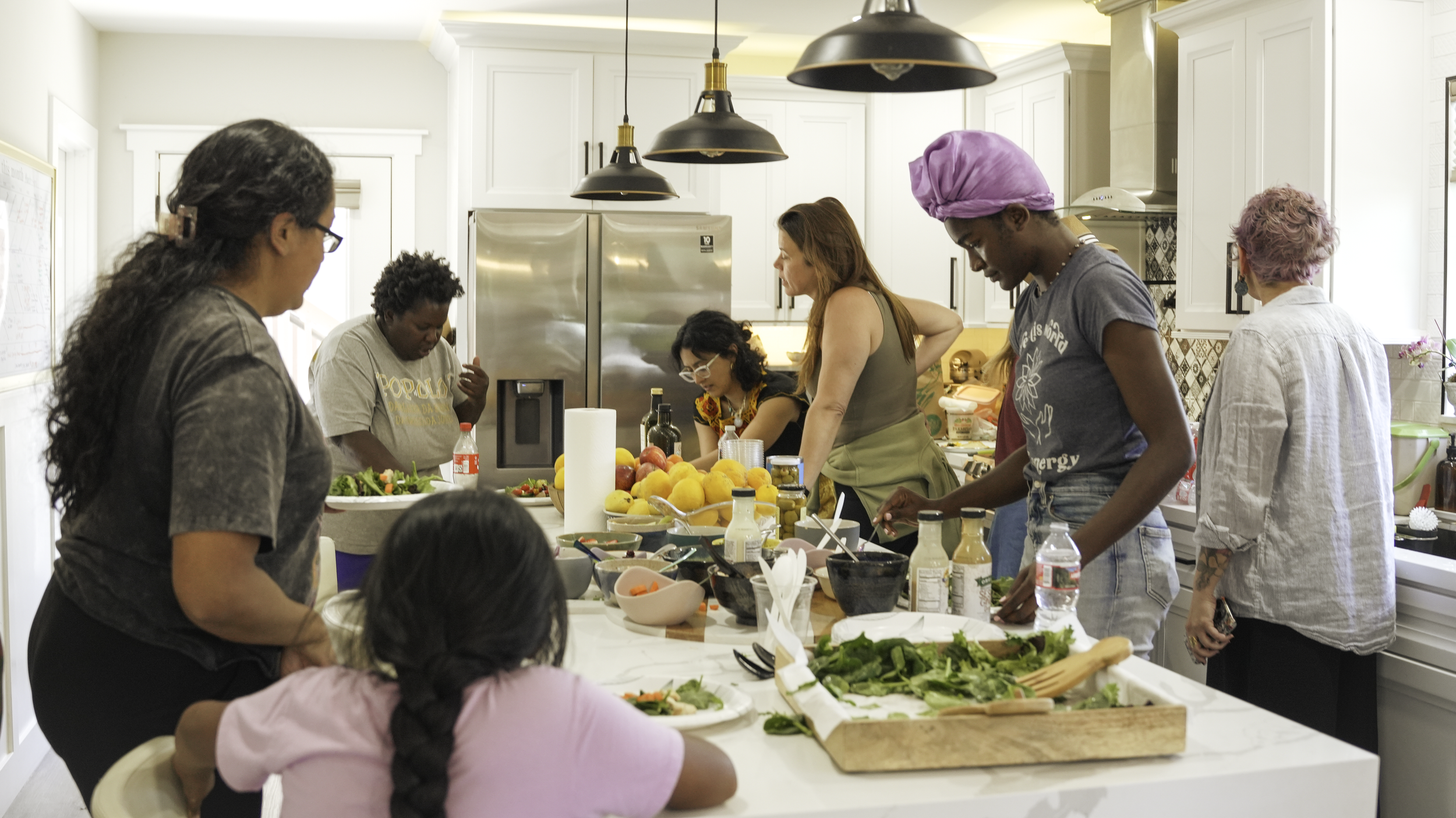 a group of women working together to prepare a meal