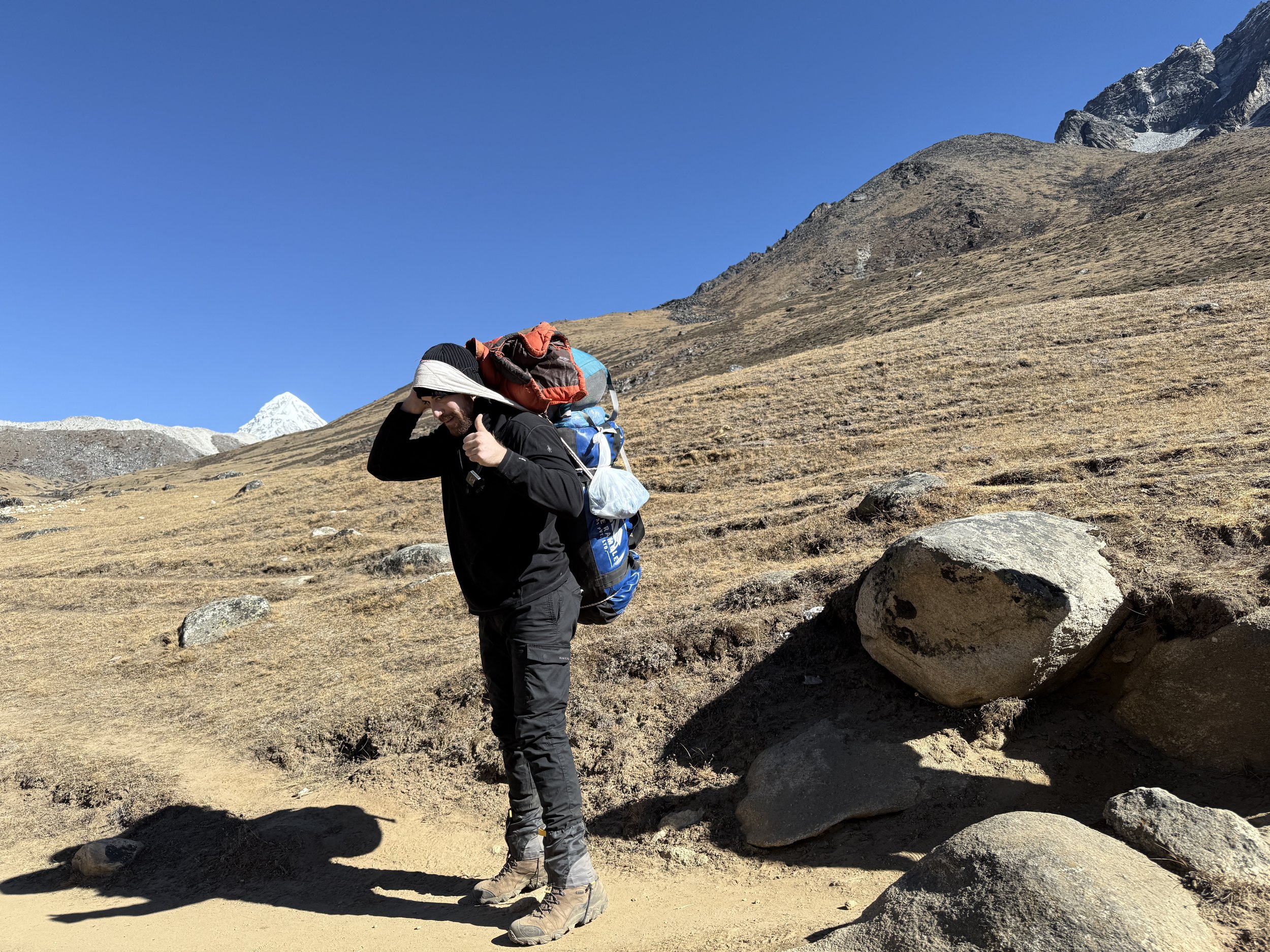 A humorous but humbling attempt to lift a Nepalese porter’s load during the EBC trek.