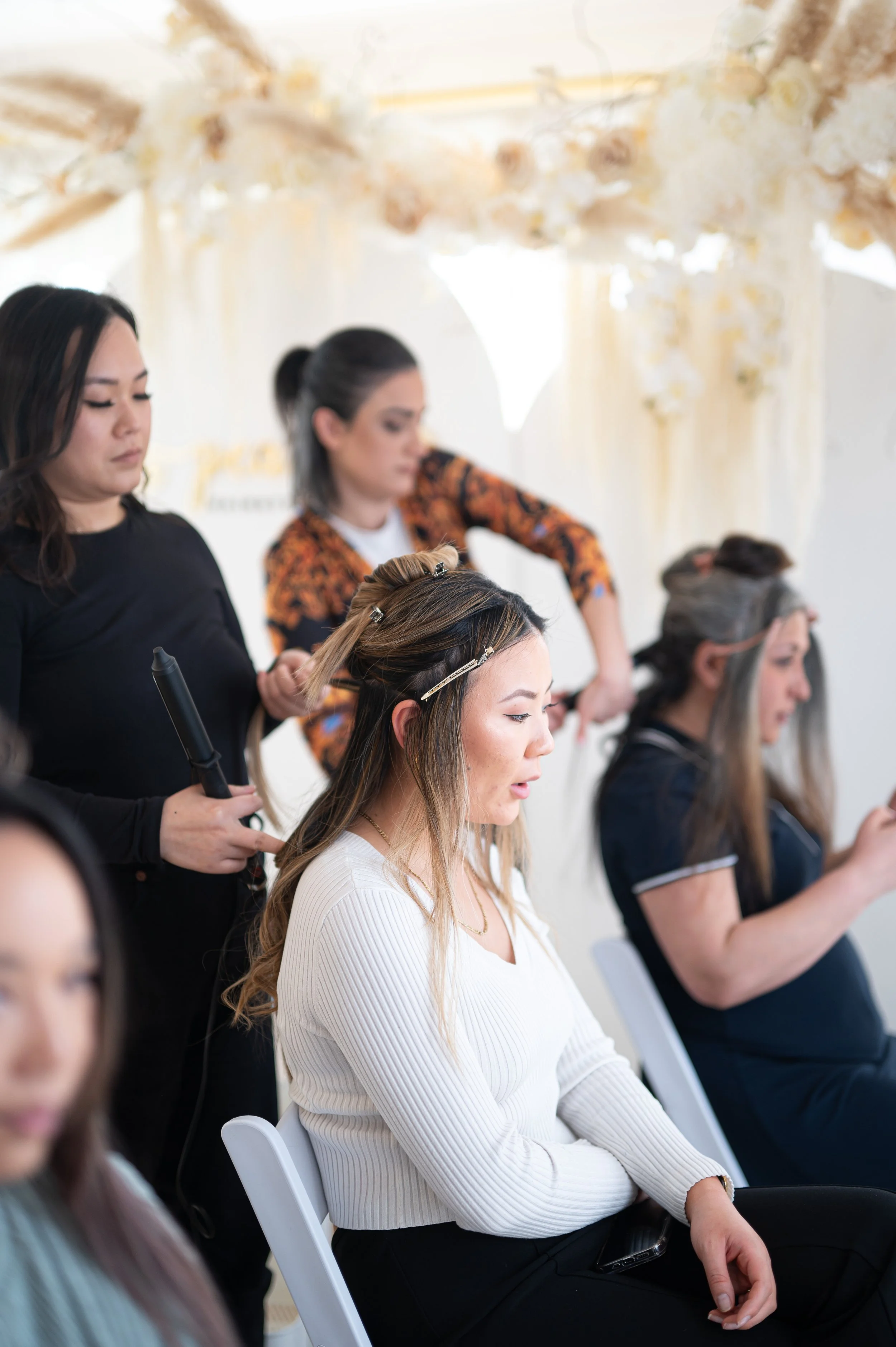 Women getting hair and makeup done at a salon.